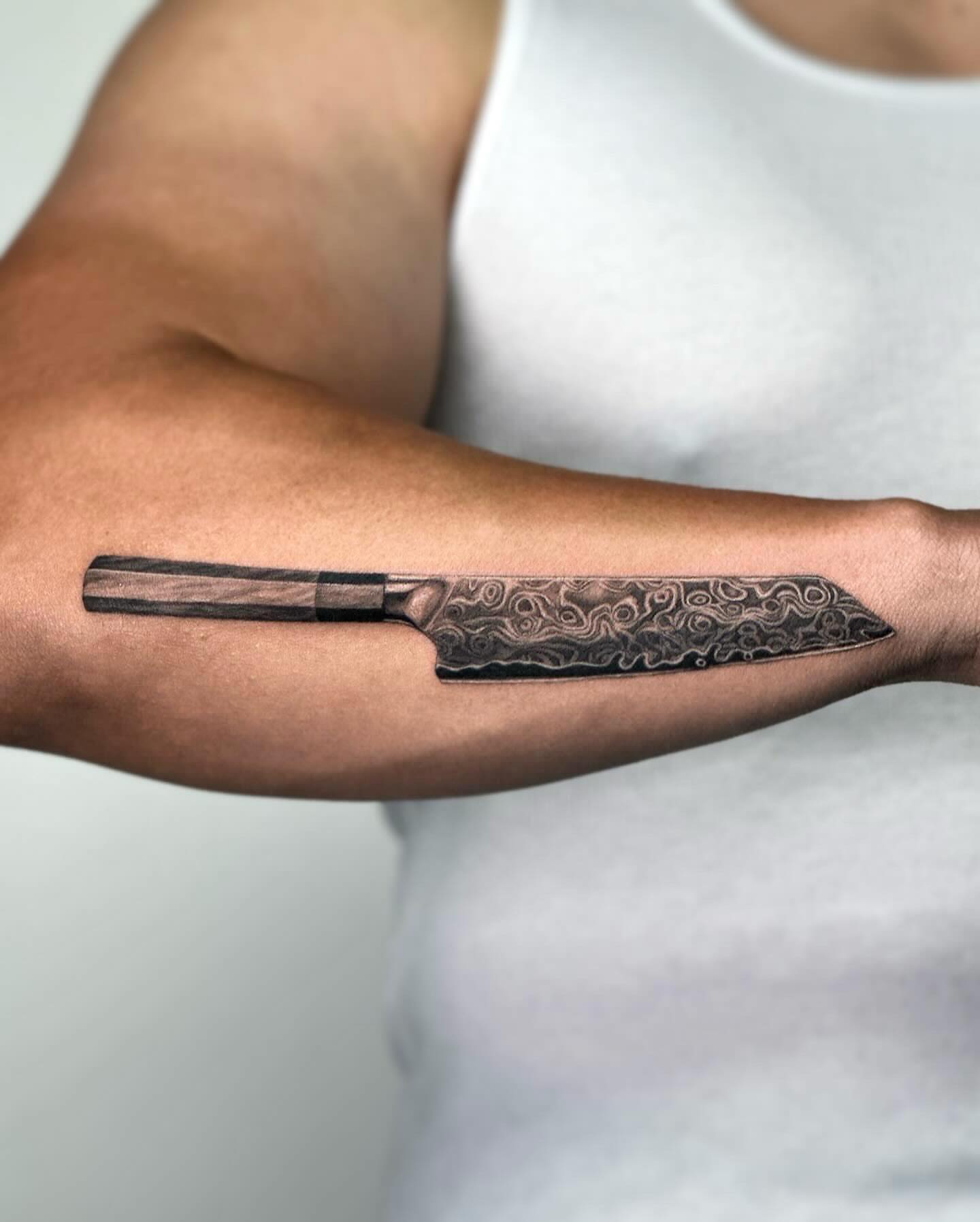 Knife black and grey tattoo on the forearm by Valery Cardona