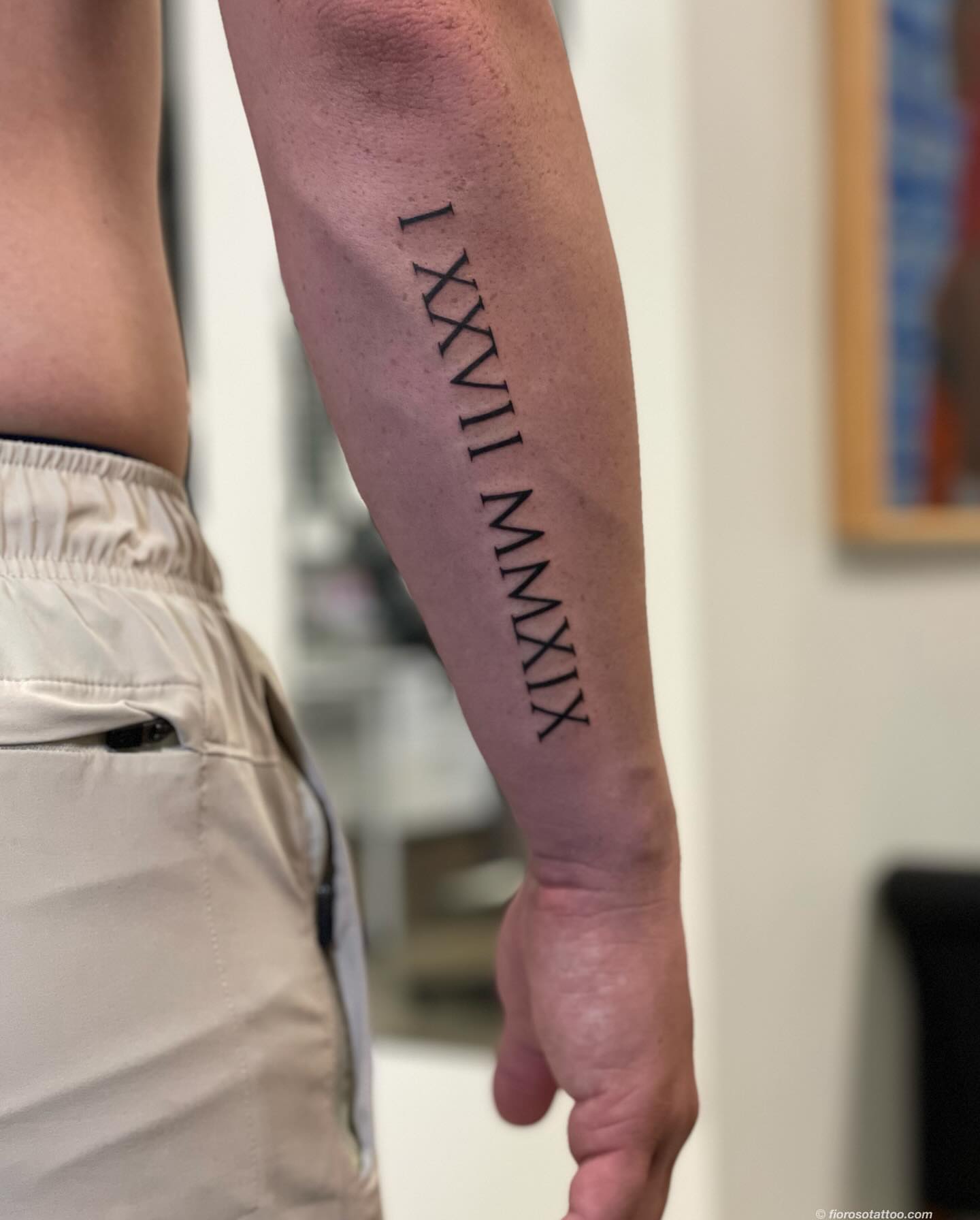 Roman numerals lettering script tattoo on the forearm by Jonathan Paul Fiore, Austin, Texas