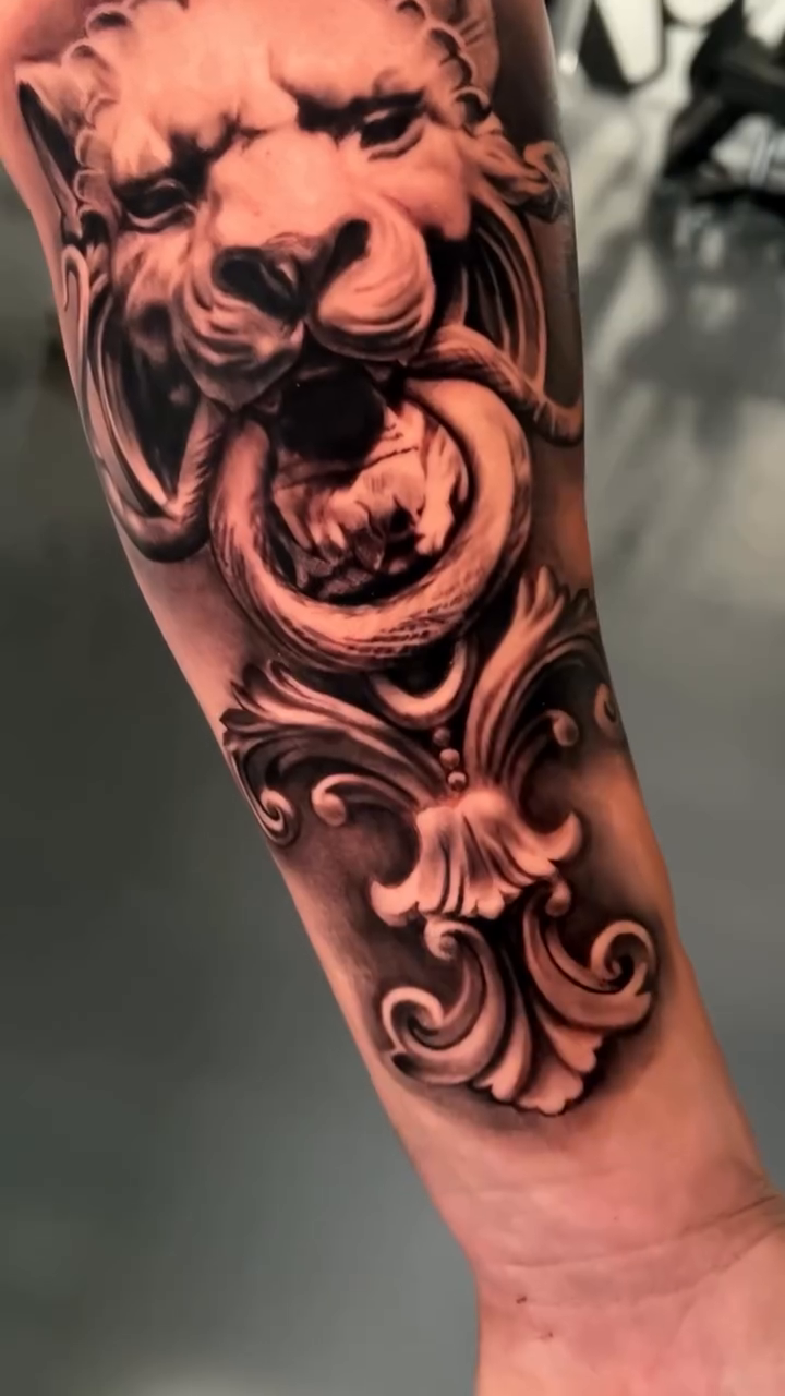 Lion head and door knocker realism tattoo by Giona Starace