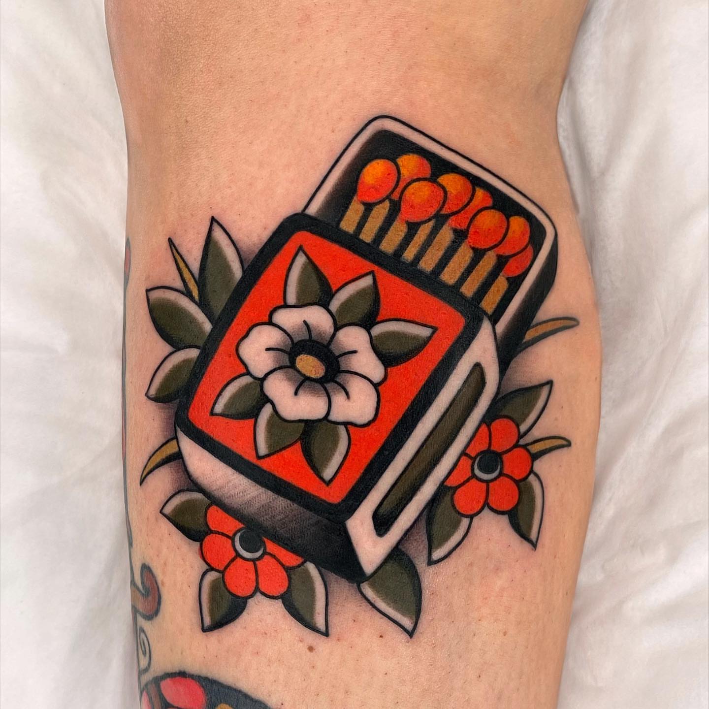 Matchbox and flowers American traditional tattoo on the forearm by Wes Hoffman