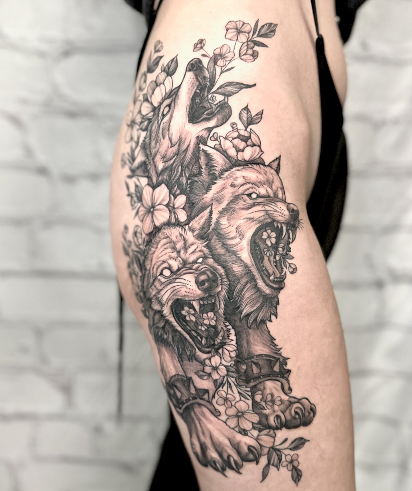 Wolves and flowers realism tattoo on the thigh by Stephen Hansen