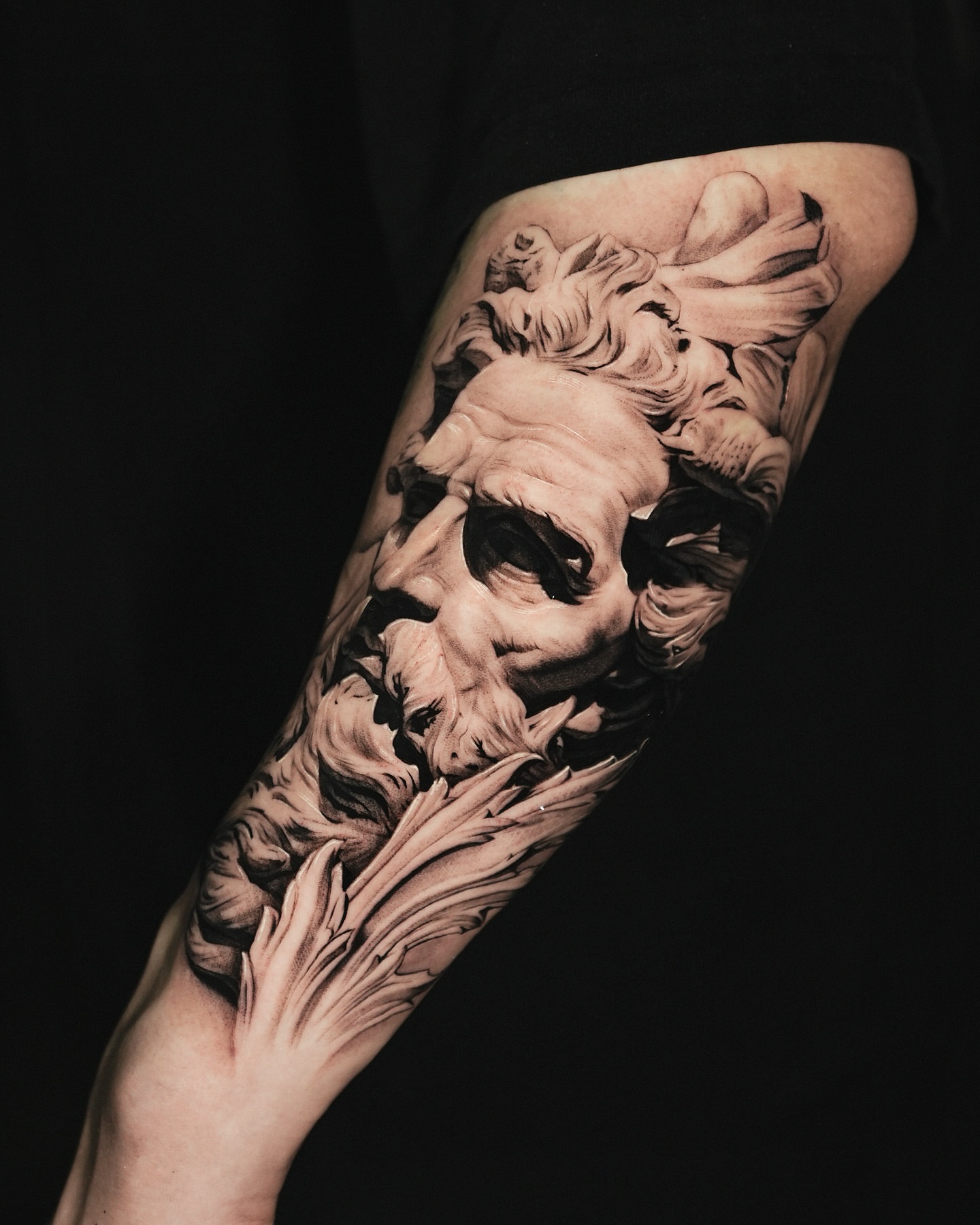 Sculptural face realism tattoo on the forearm by Kid Needle