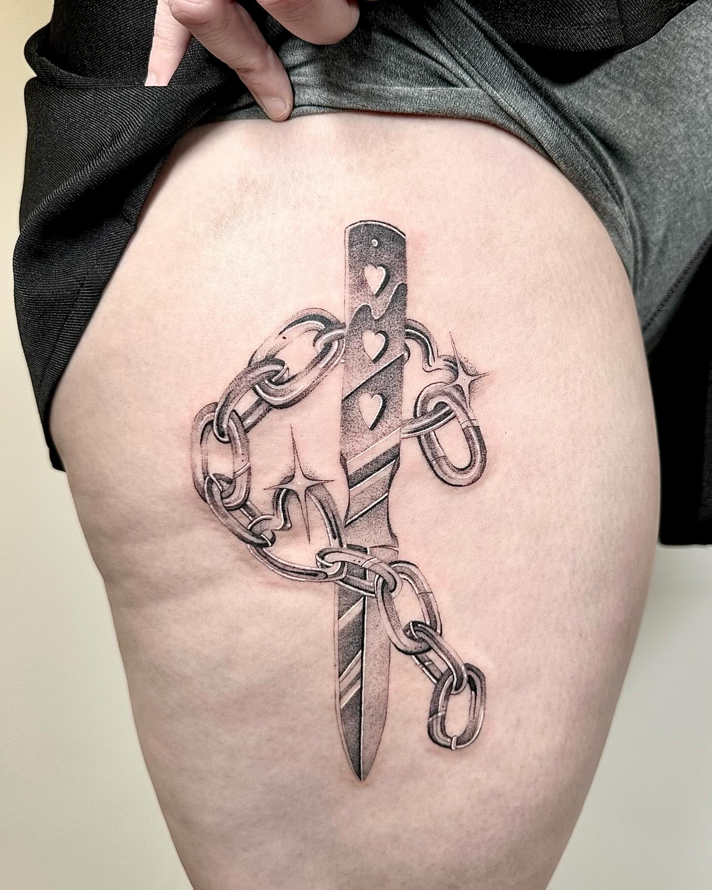 Knife and chain black and grey tattoo on the thigh by Fine line tattoo San Diego, San Diego, California