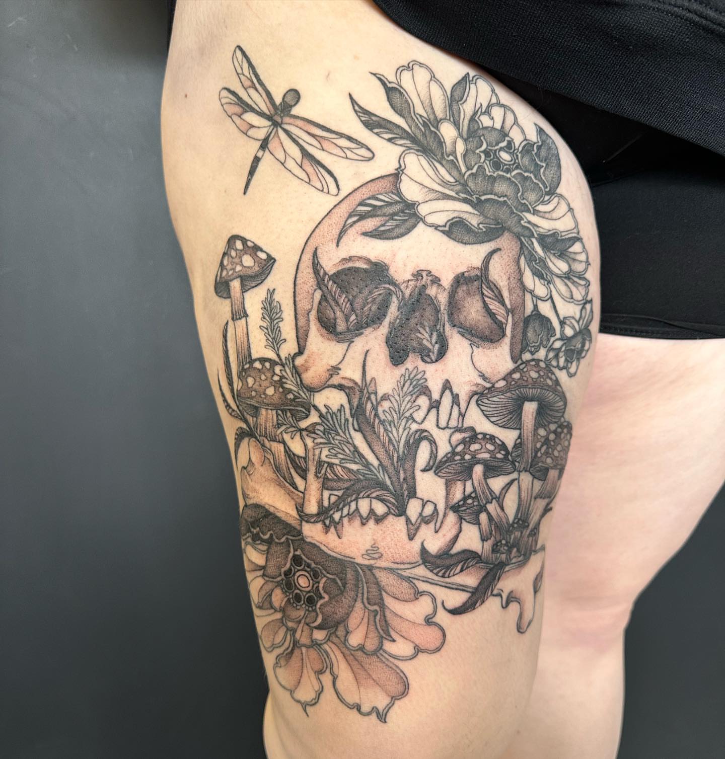 Skull with flora realism tattoo on the thigh by 𝕵𝖊𝖘𝖘𝖆 𝕭𝖎𝖌𝖊𝖑𝖔𝖜, Harrison, New Jersey