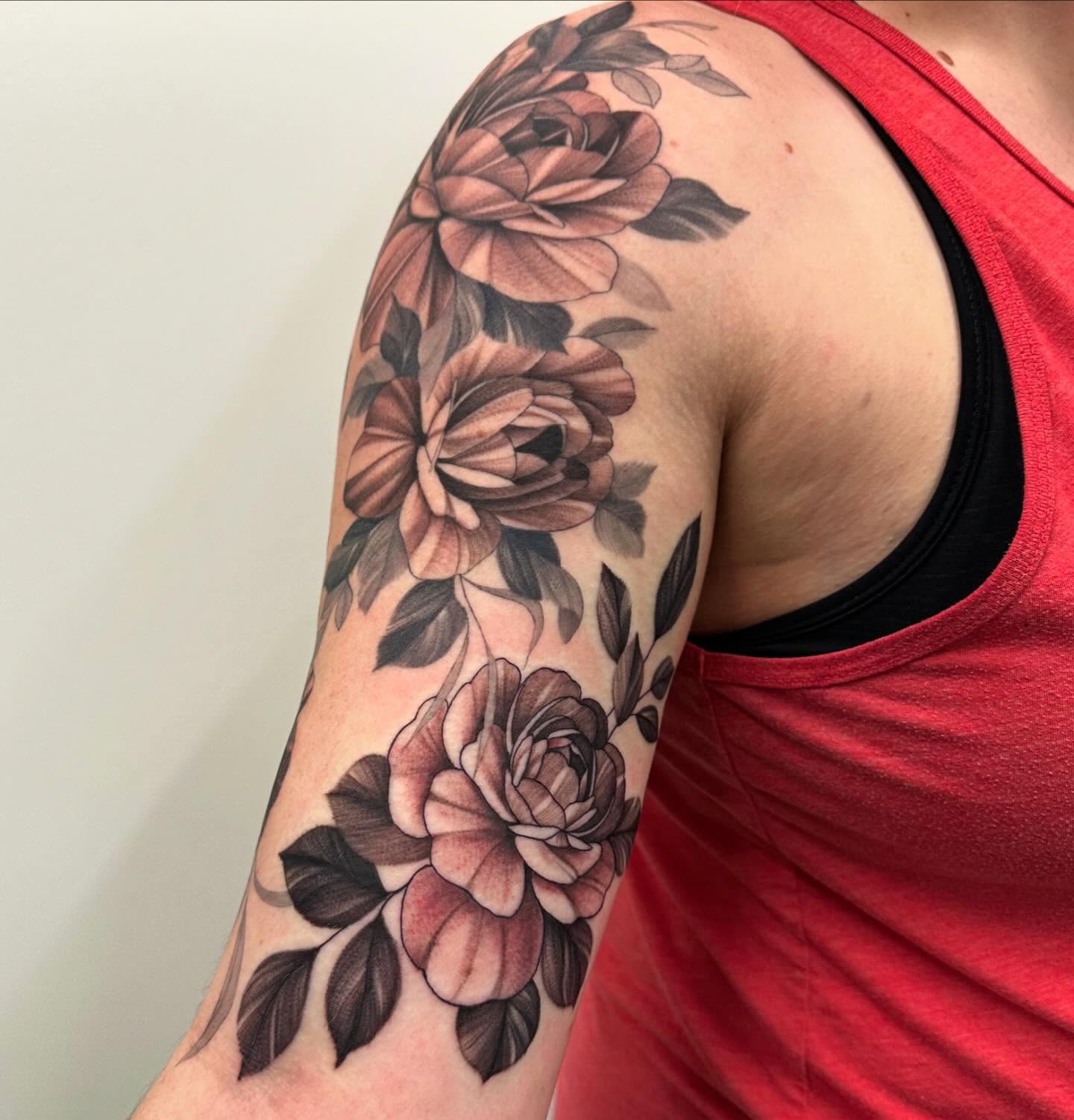 Floral bouquet realism tattoo on the upper arm by Sam Oakes