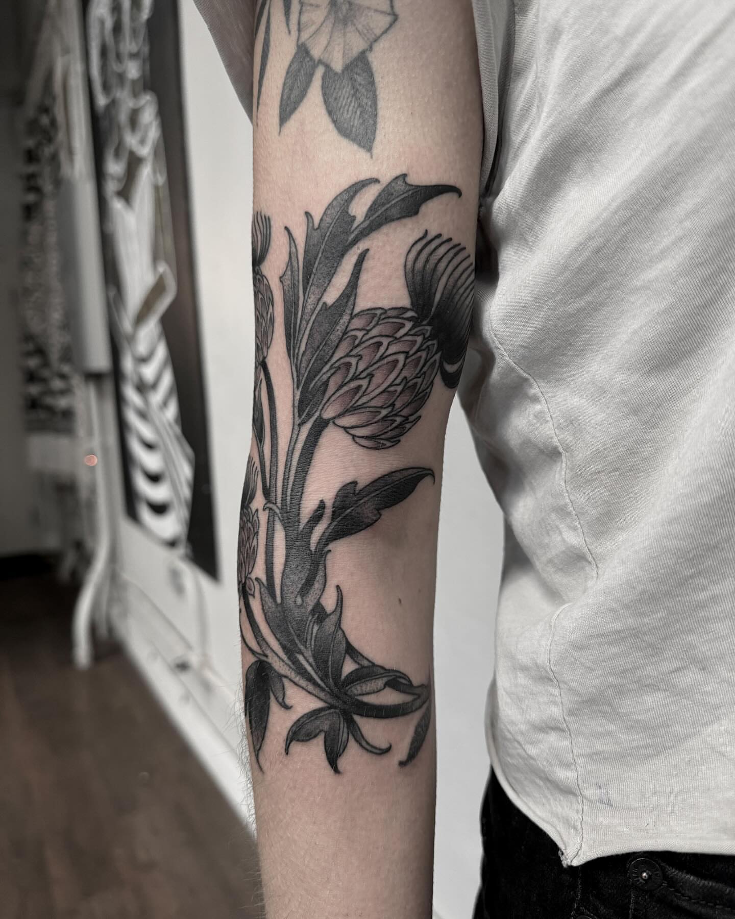 Flower black and grey tattoo on the forearm by gina