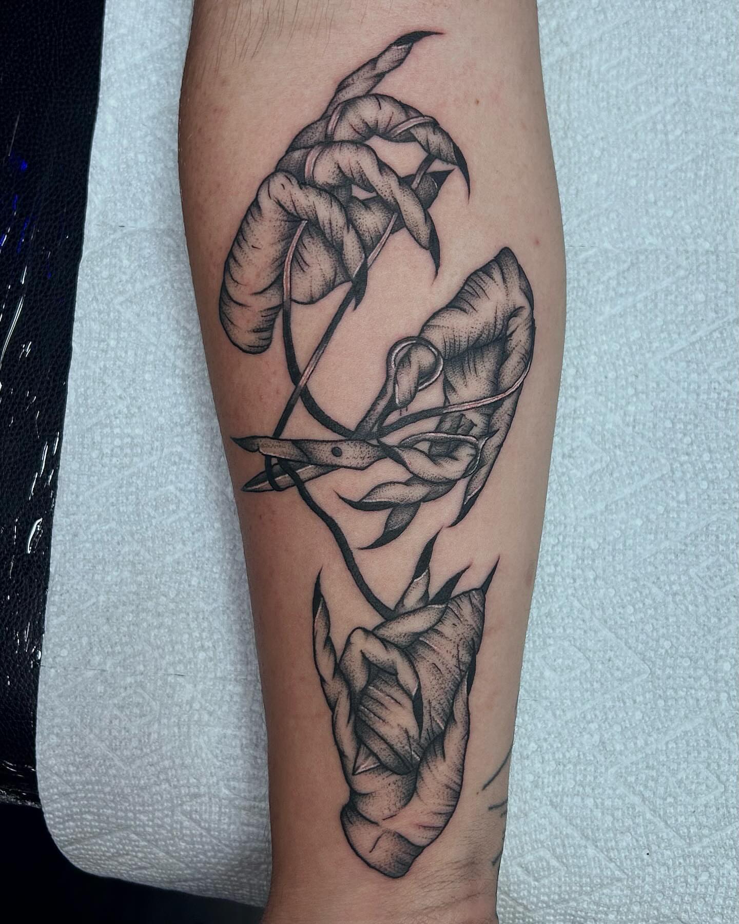 Scissors cutting string dotwork tattoo on the forearm by Colby McClain