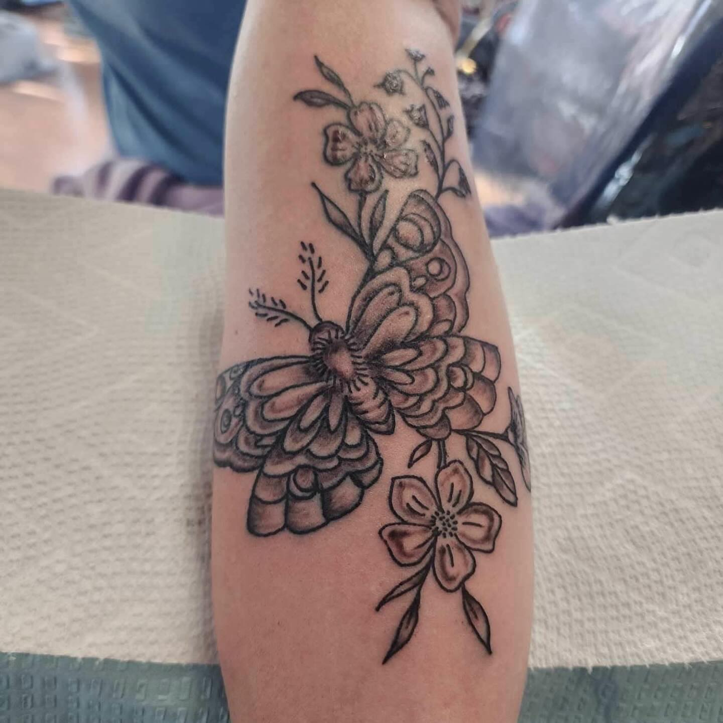 Floral arrangement black and grey tattoo on the forearm by Strange Brew Tattoo