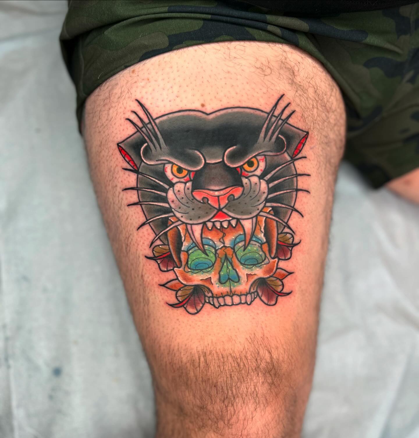 Panther skull American traditional tattoo on the thigh by Noah Crow