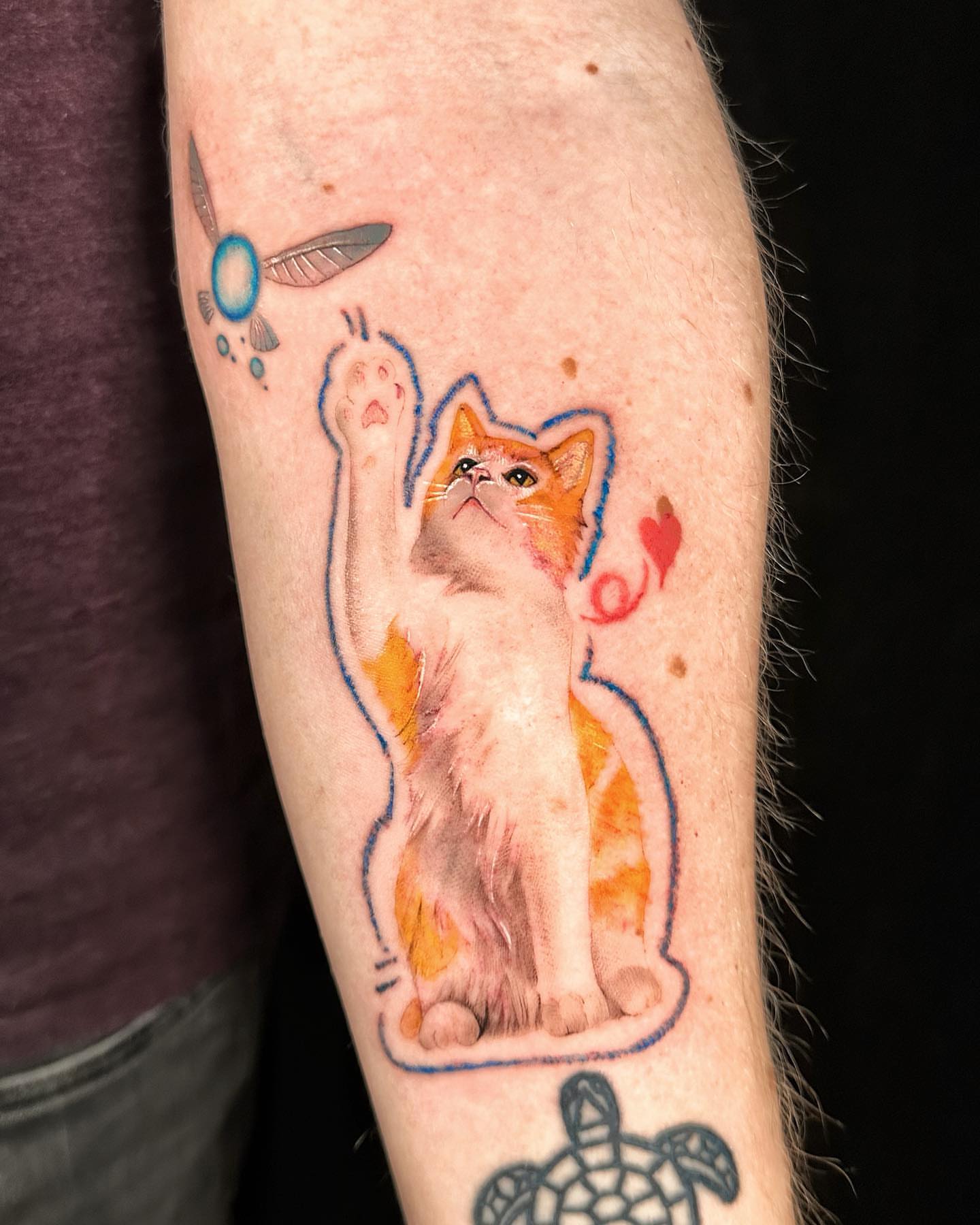 Cat reaching for feather realism tattoo on the forearm by Alice Li, Houston, Texas