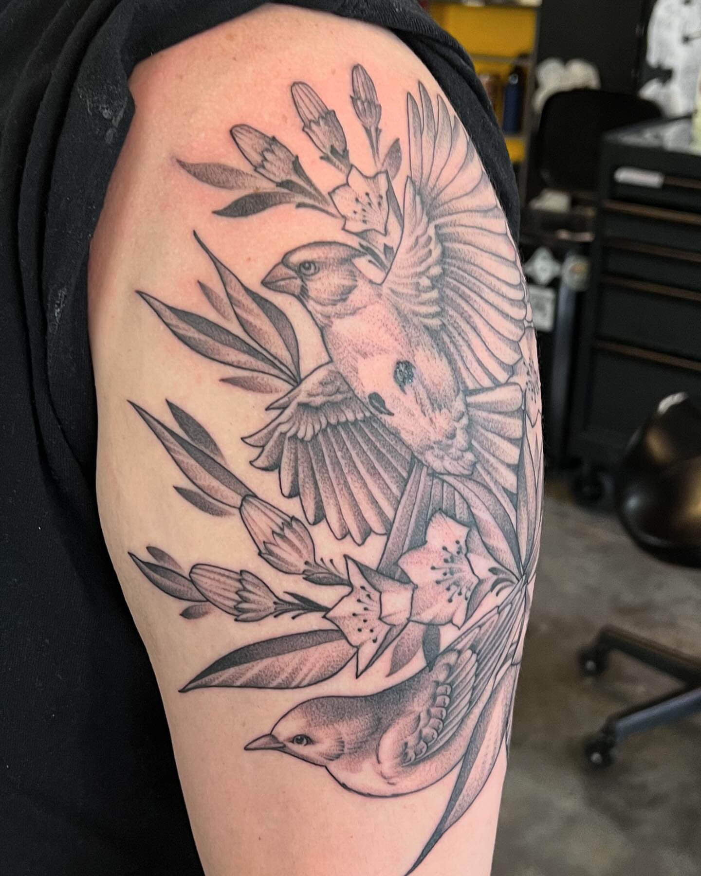 Birds and flowers realism tattoo on the upper arm by Will Campbell