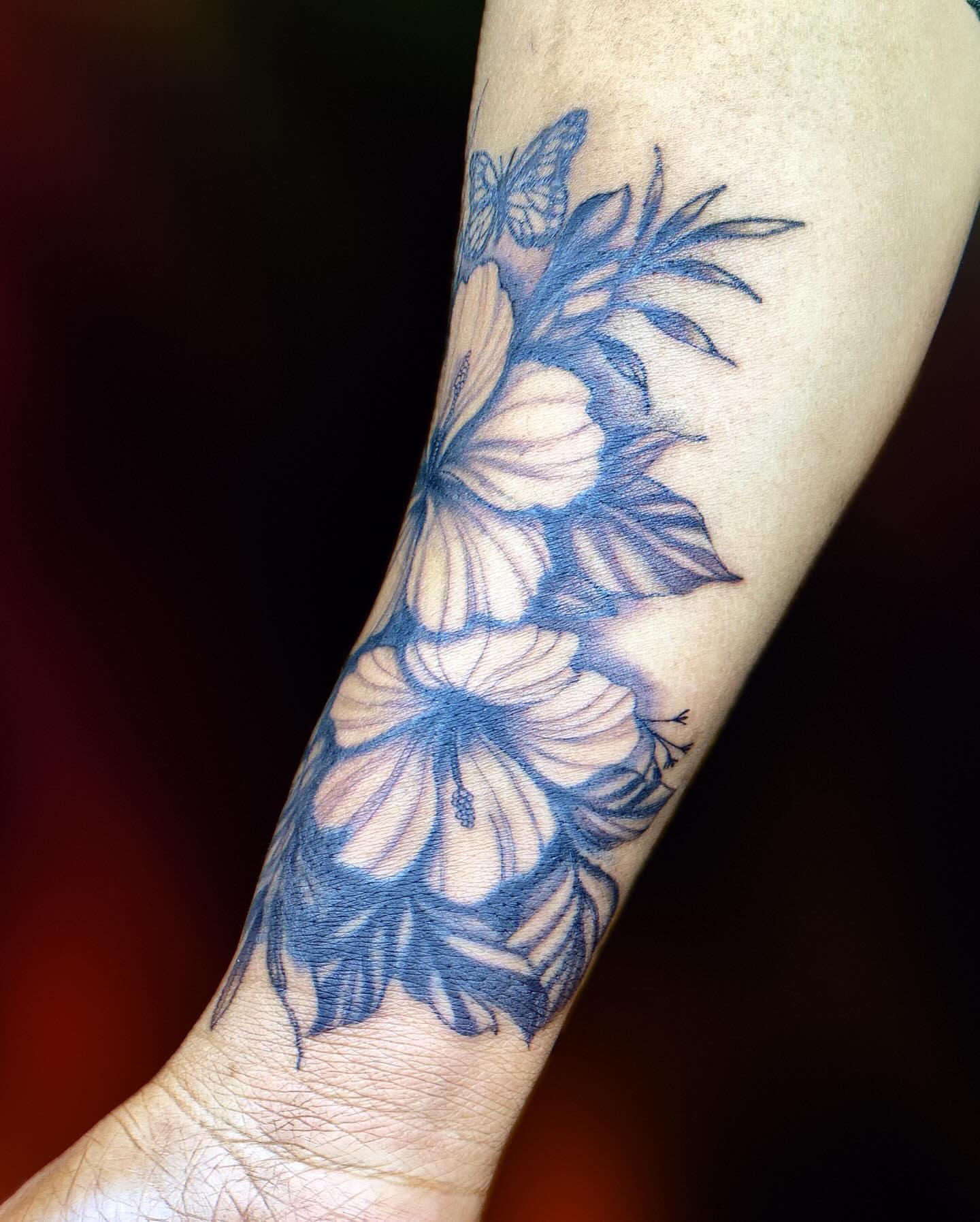 Flowers and butterflies realism tattoo on the forearm by Tiffany