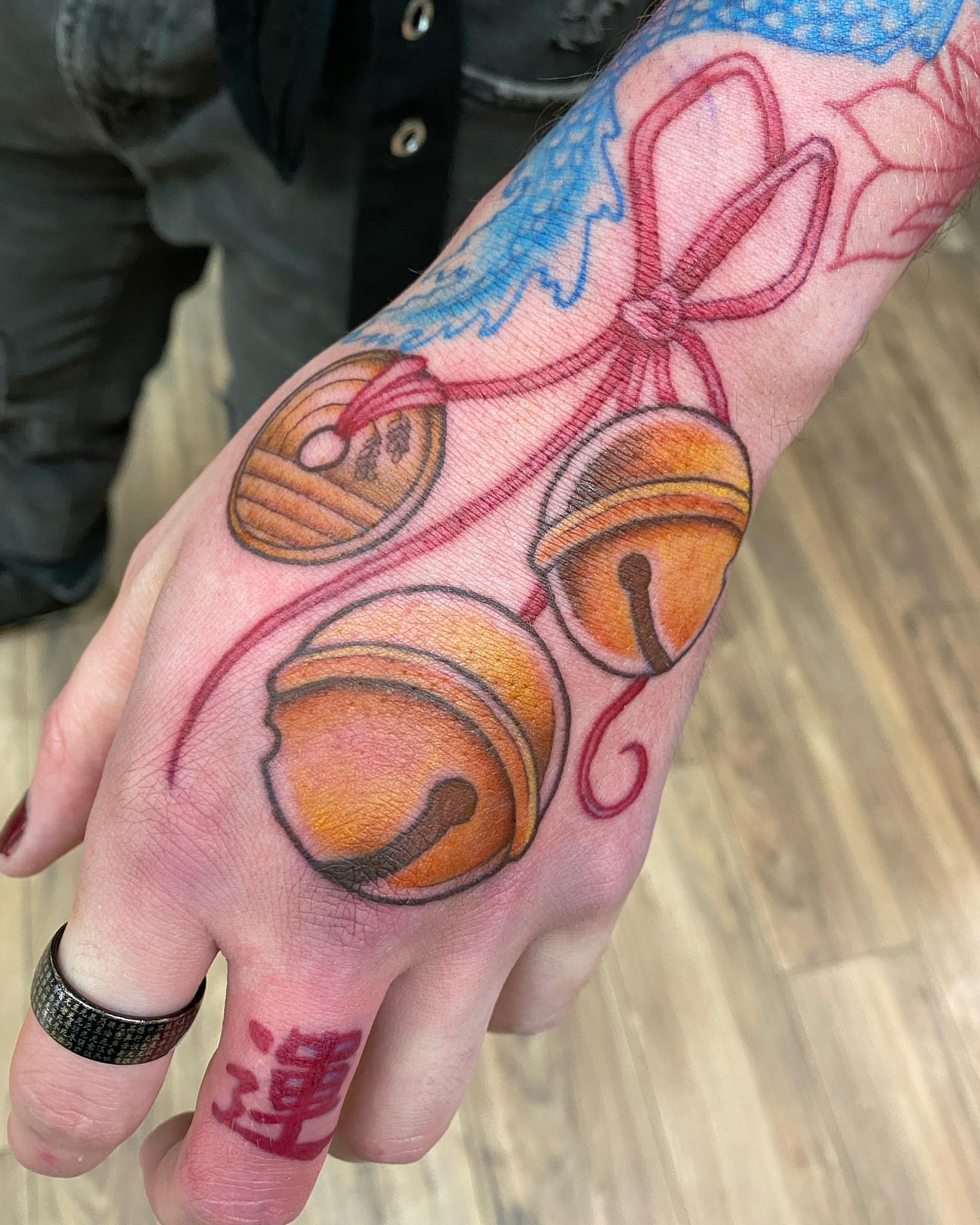 Jingle bells American traditional tattoo on the hand by Savanna Starr Mortensen