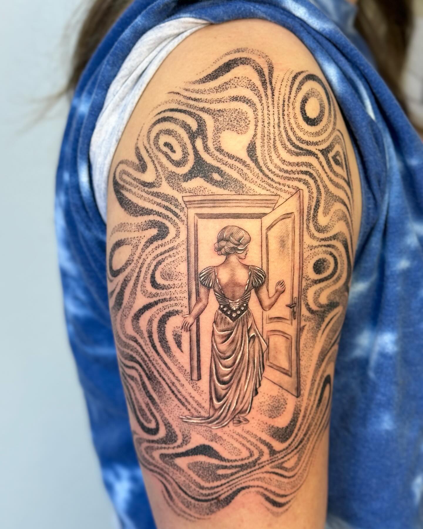 Door opening with woman dotwork tattoo on the upper arm by Ian Spencer