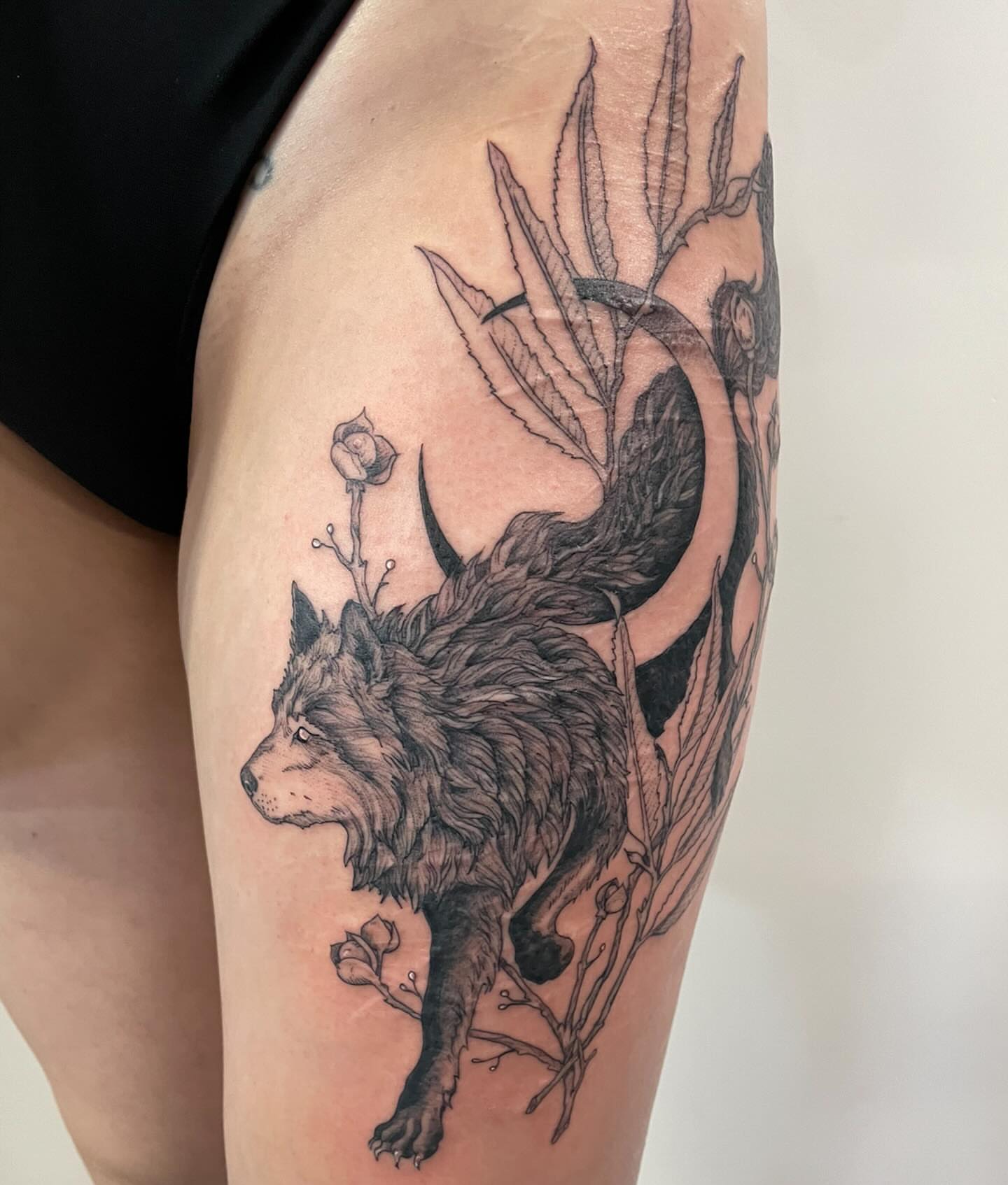 Wolf and plant realism tattoo on the thigh by Christen Wolfe CA Tattooer
