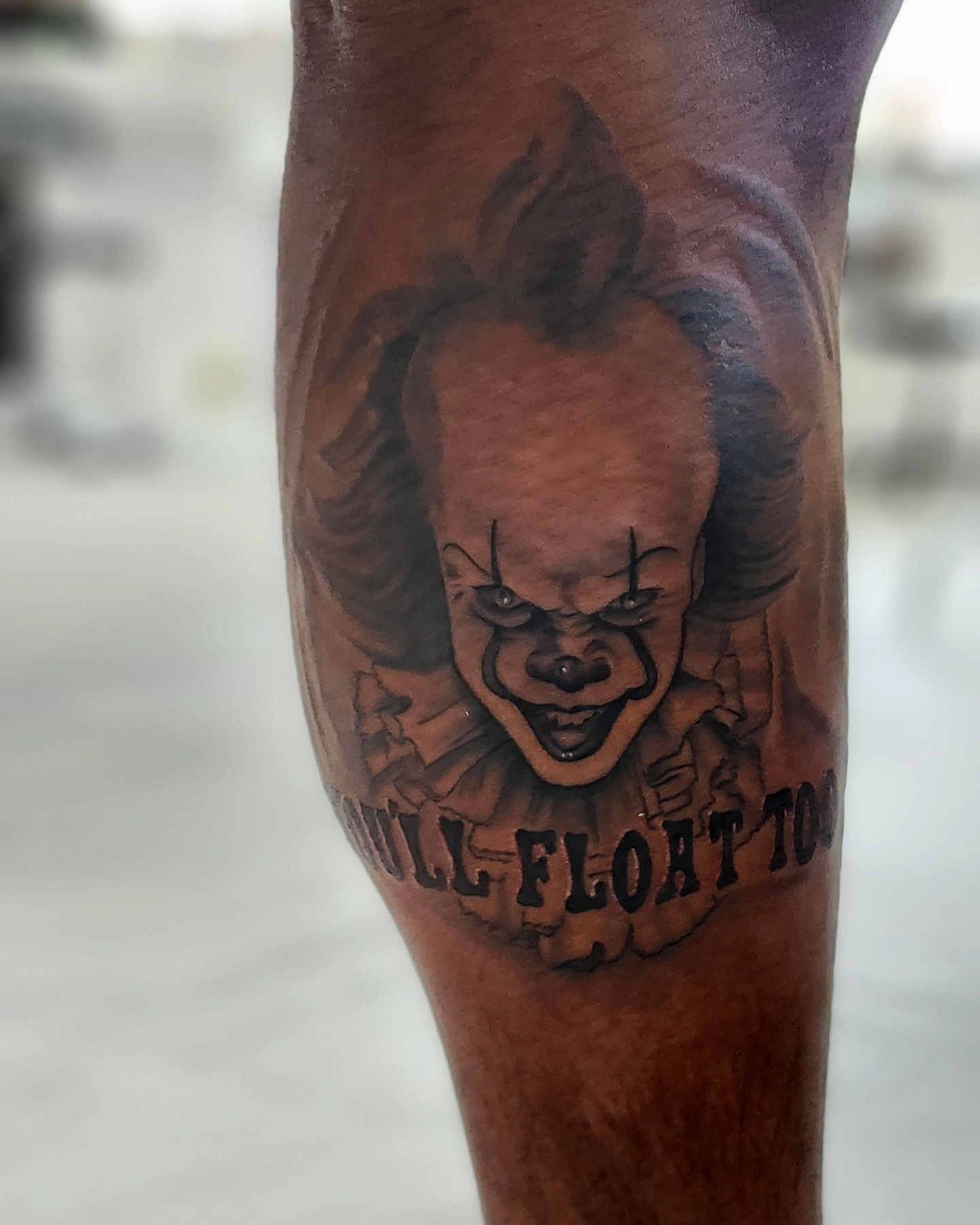 Pennywise black and grey tattoo on the forearm by Herc