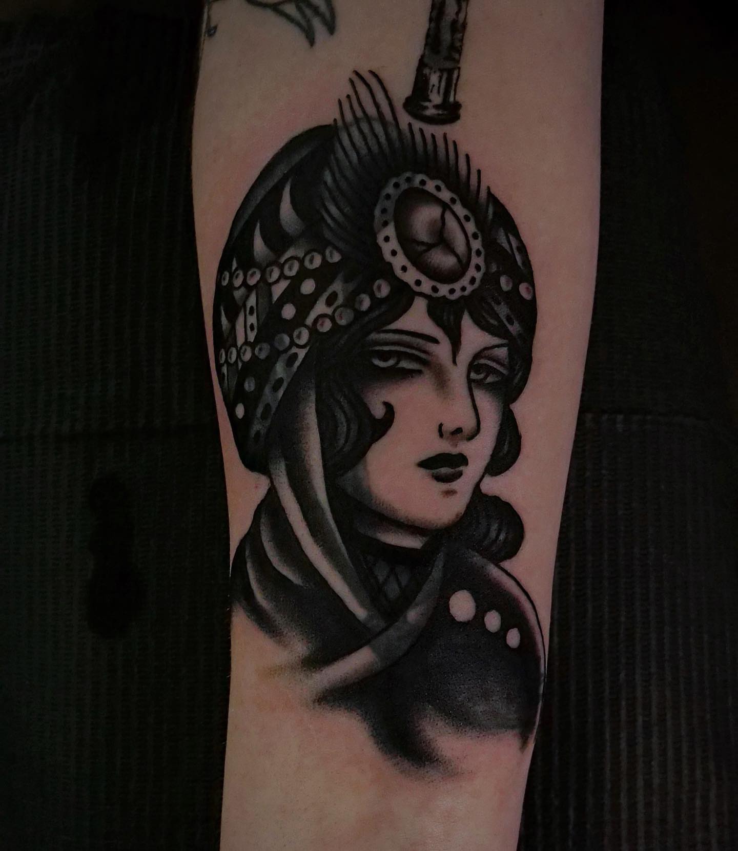 Woman with headdress black and grey tattoo on the forearm by Brandon Murphy