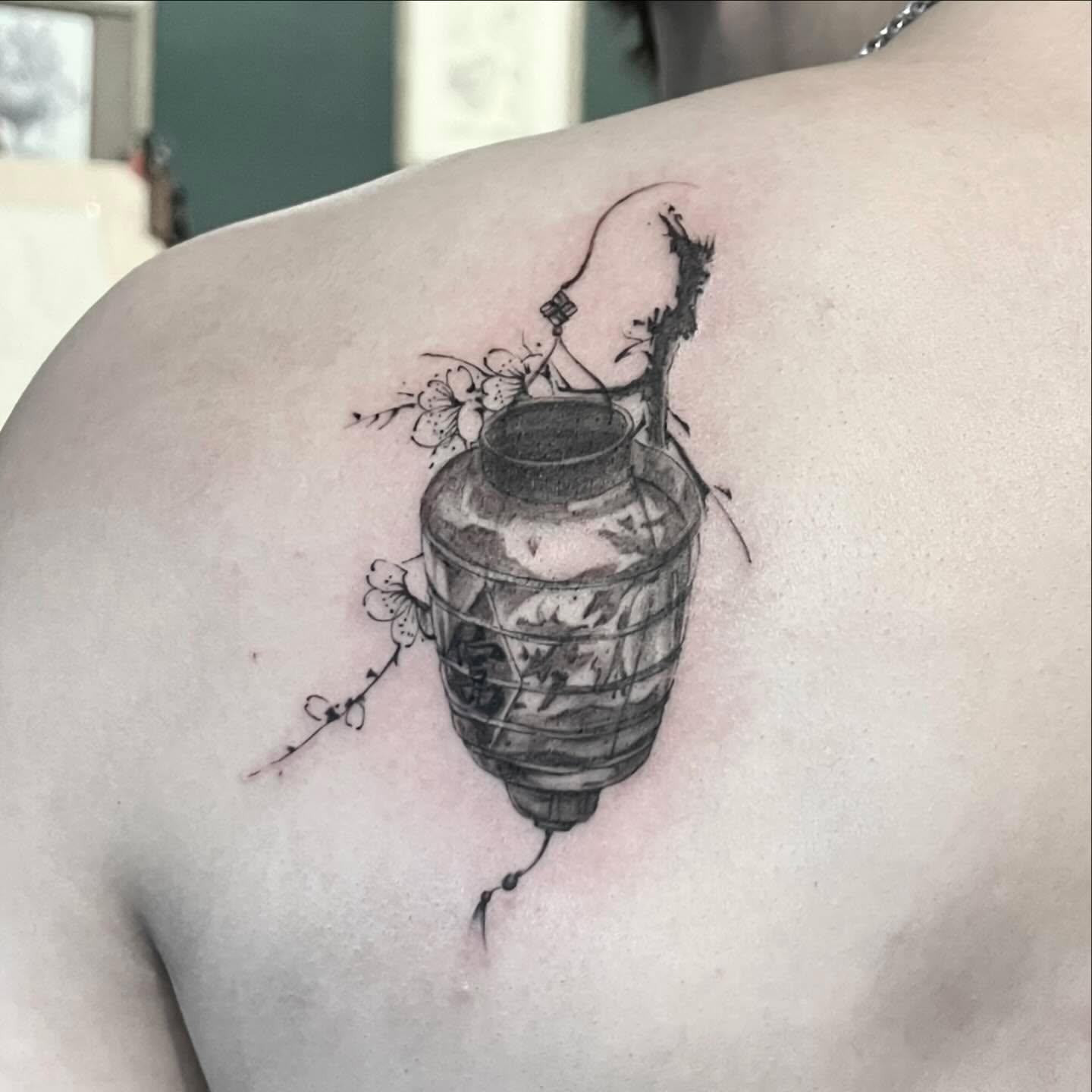 Lantern with flowers black and grey tattoo on the shoulder by G̵̨̗̗̈̅̓́͡ĕ̸̡̜̫̾̌̎̈͠ë̷̢̳̤̰̗͈̃͌͒̚͞