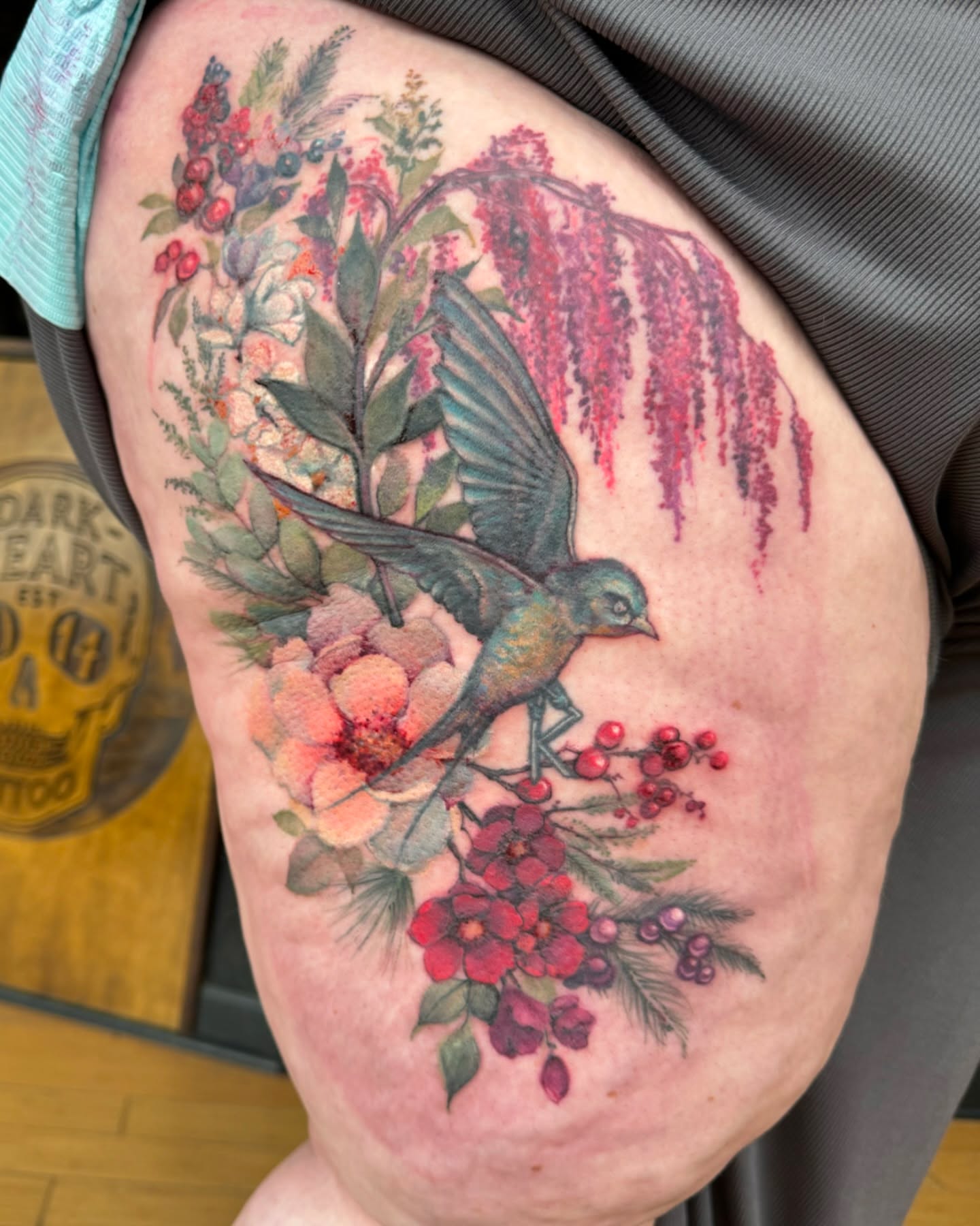 Bird and floral arrangement watercolor tattoo on the thigh by Sarah Spread