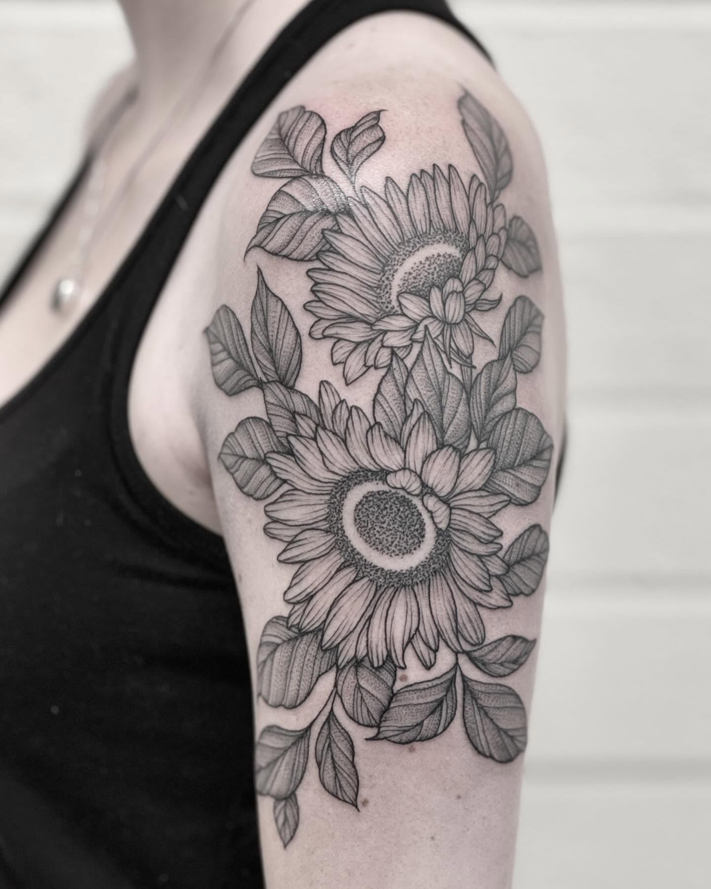 Sunflowers black and grey tattoo on the upper arm by Alex Shakuto Tattoo