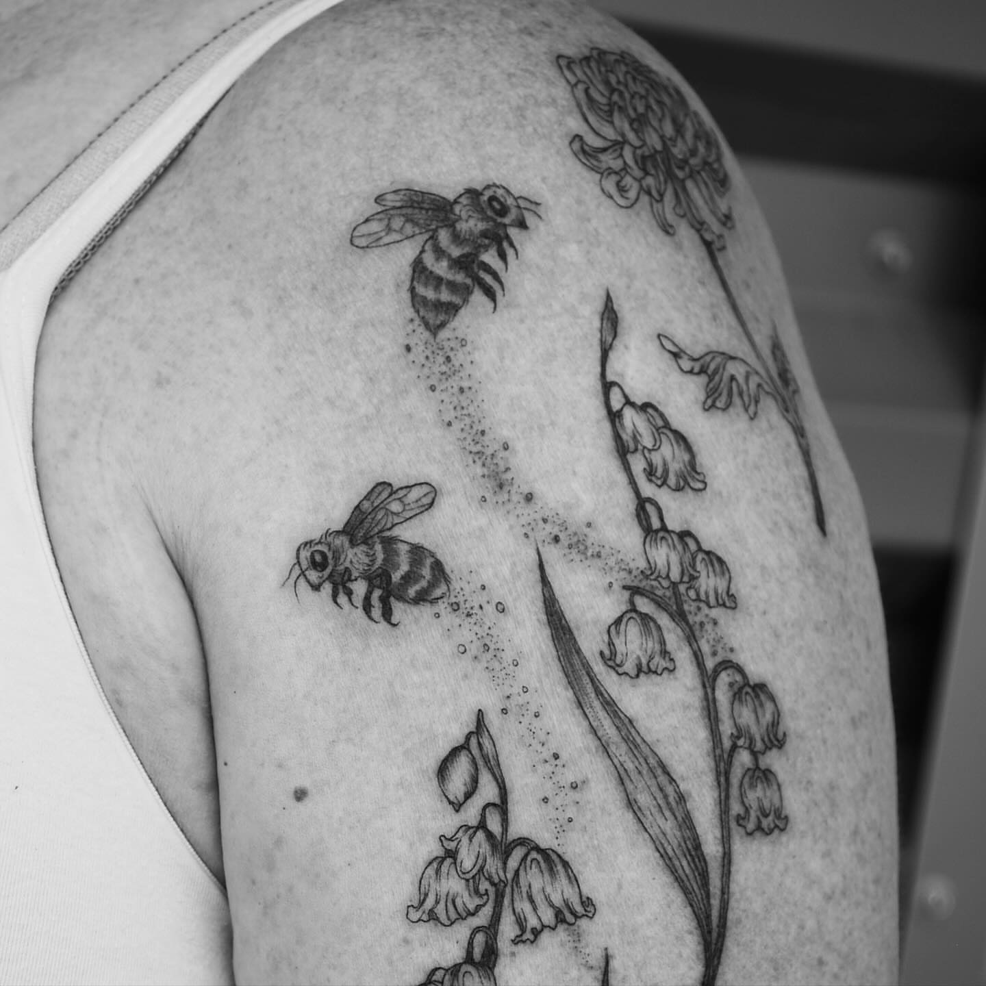 Bees and flowers dotwork tattoo on the shoulder by Seraphim