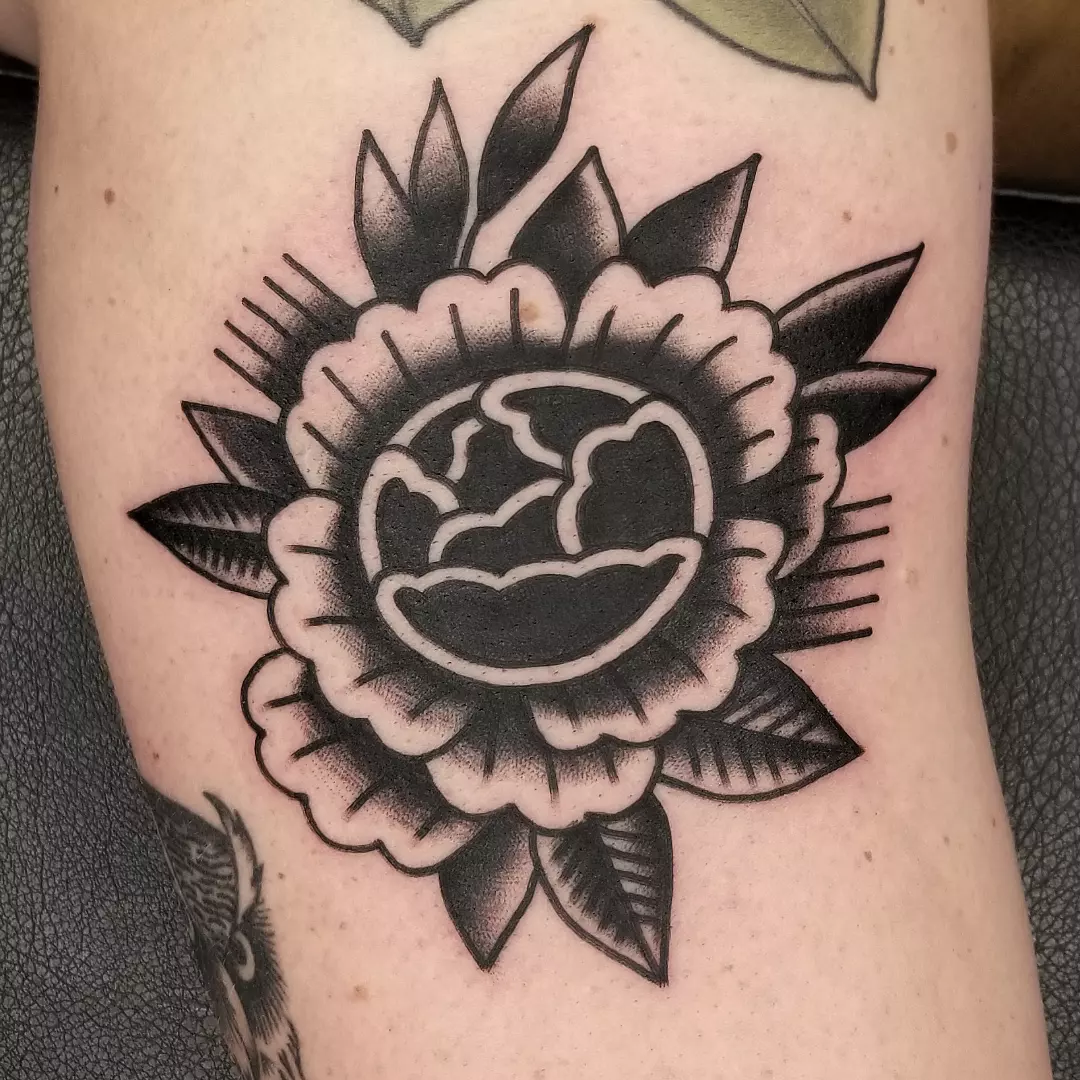 Smiling face with flower American traditional tattoo on the forearm by Deke Harms, Bend, Oregon