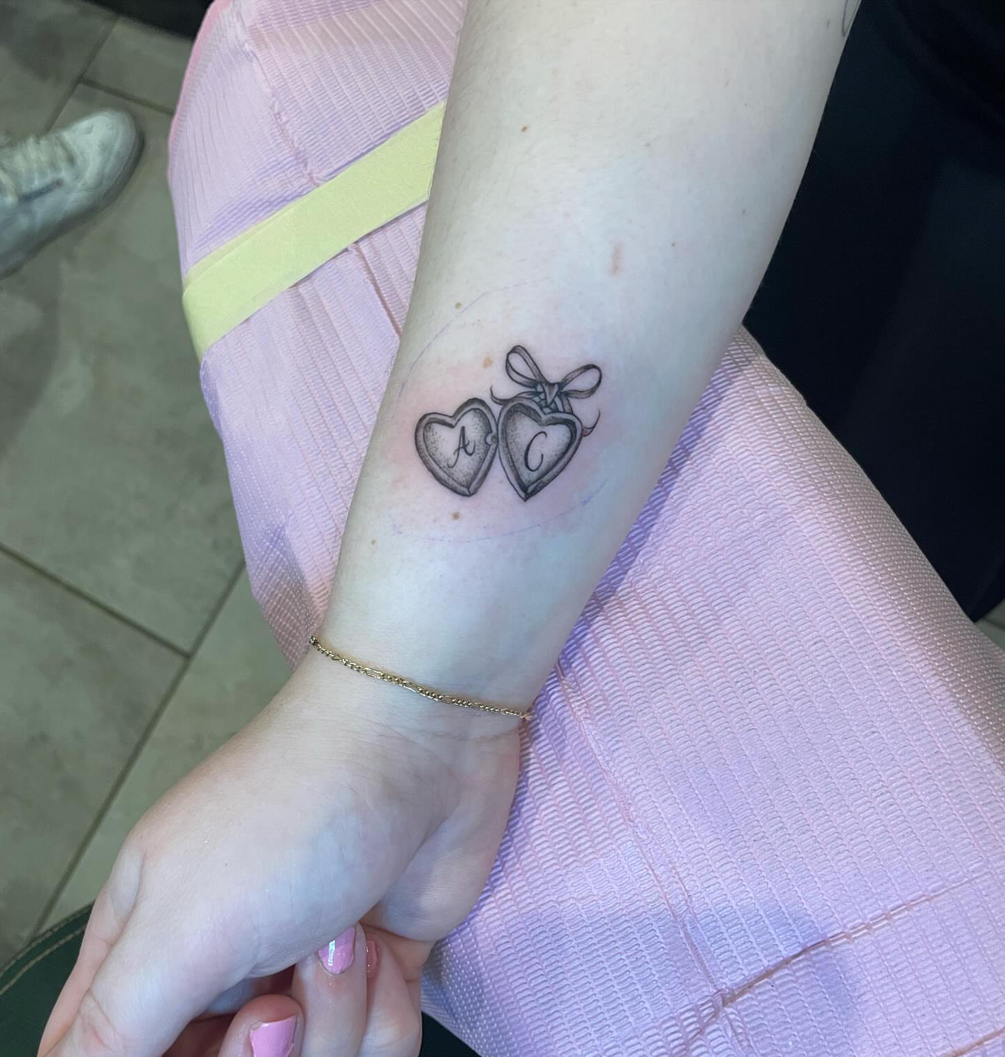 Heart-shaped lockets black and grey tattoo on the forearm by Kimberly Shordon