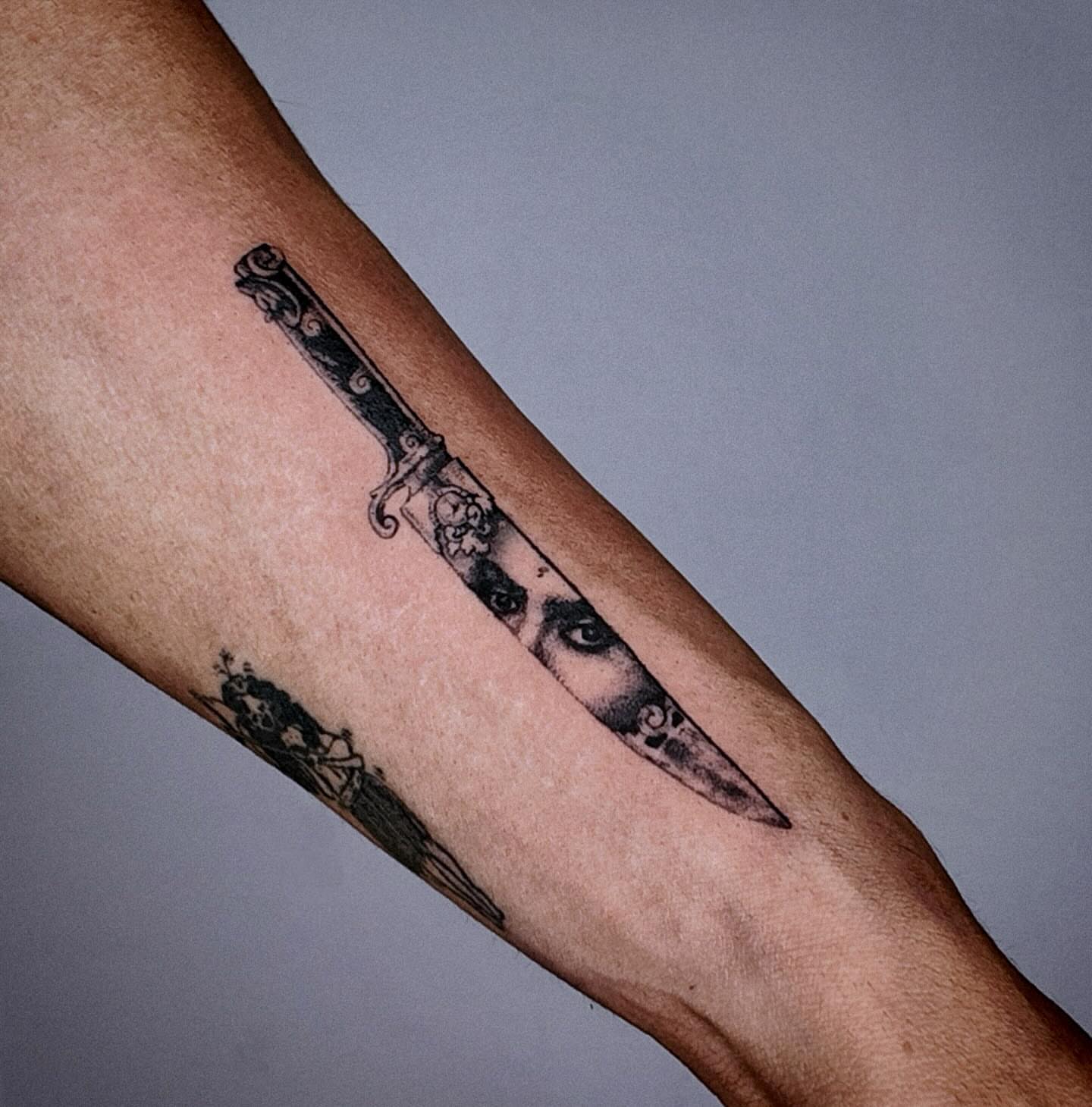 Knife black and grey tattoo on the forearm by Gabriel
