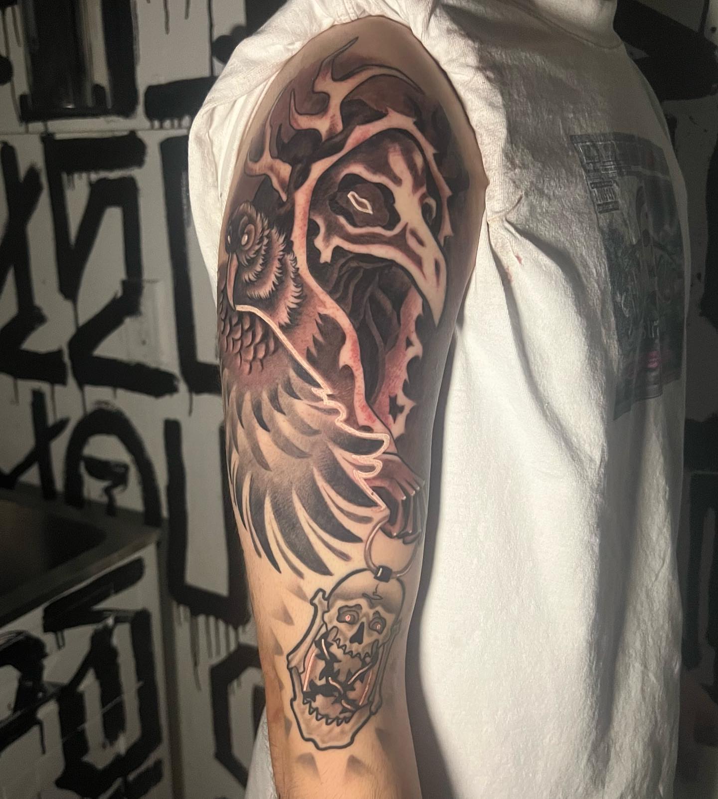 Bird and skull neo-traditional tattoo on the upper arm by Brittney
