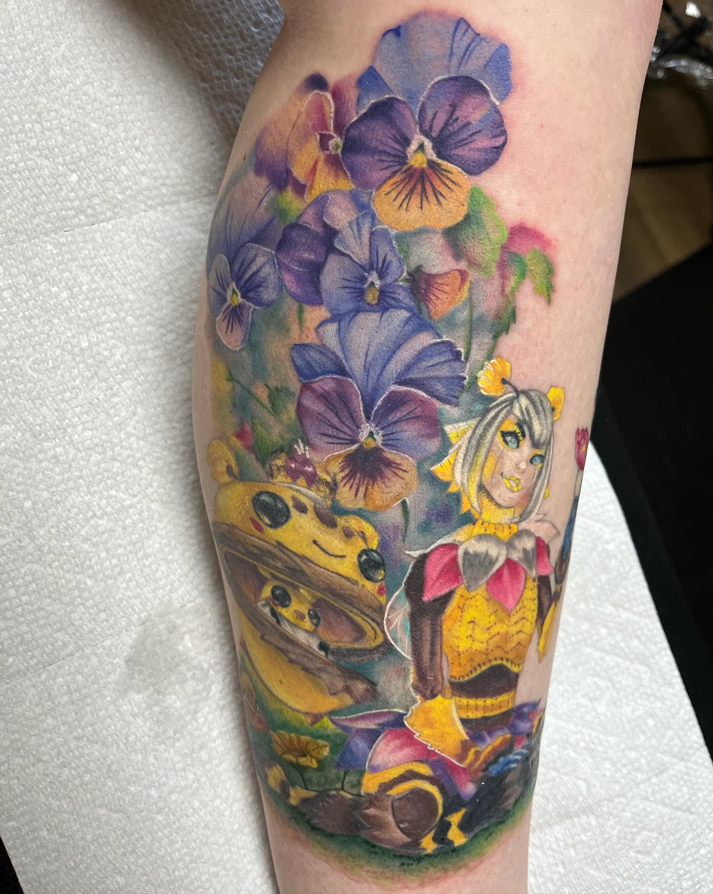 Flower and character watercolor tattoo on the forearm by Tina Gregg, North Ridgeville, Ohio