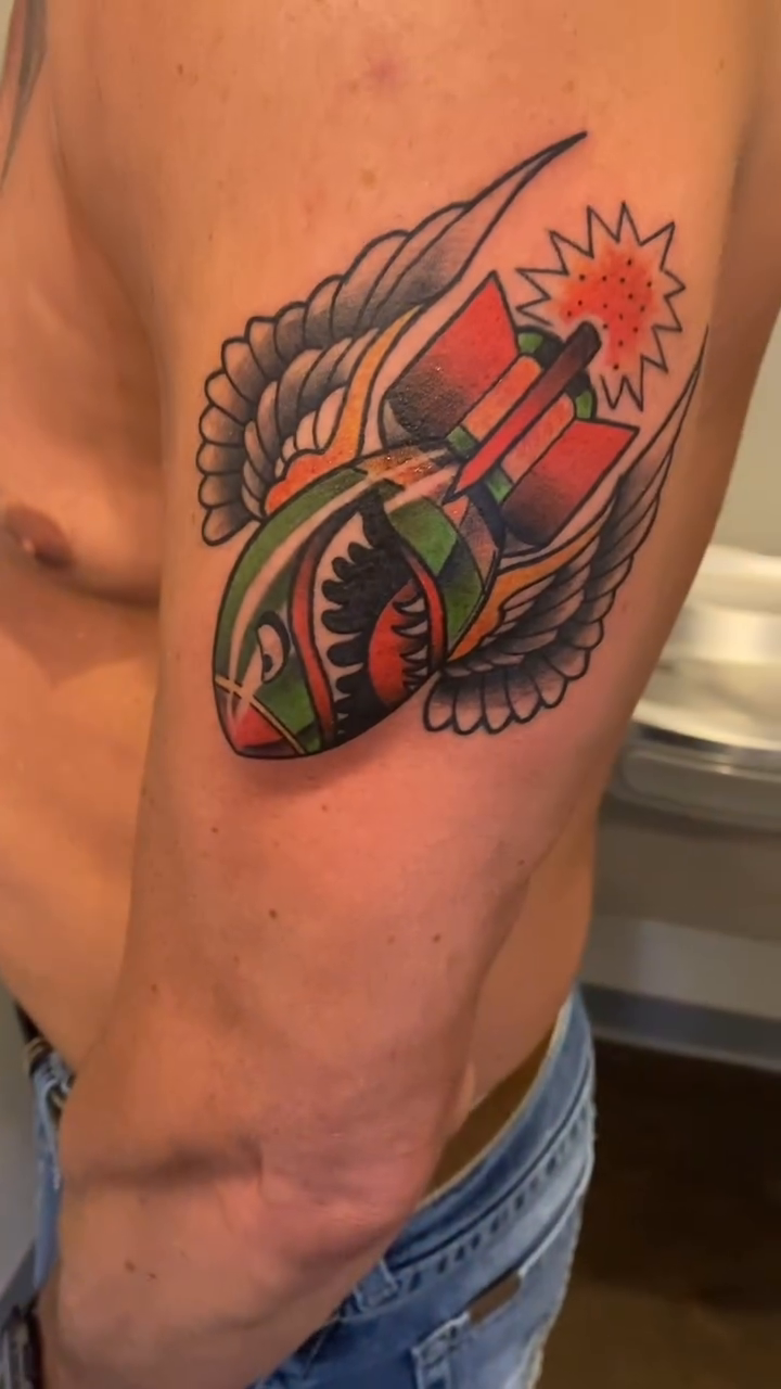 Bomb with wings American traditional tattoo on the upper arm by Cody Wolfe