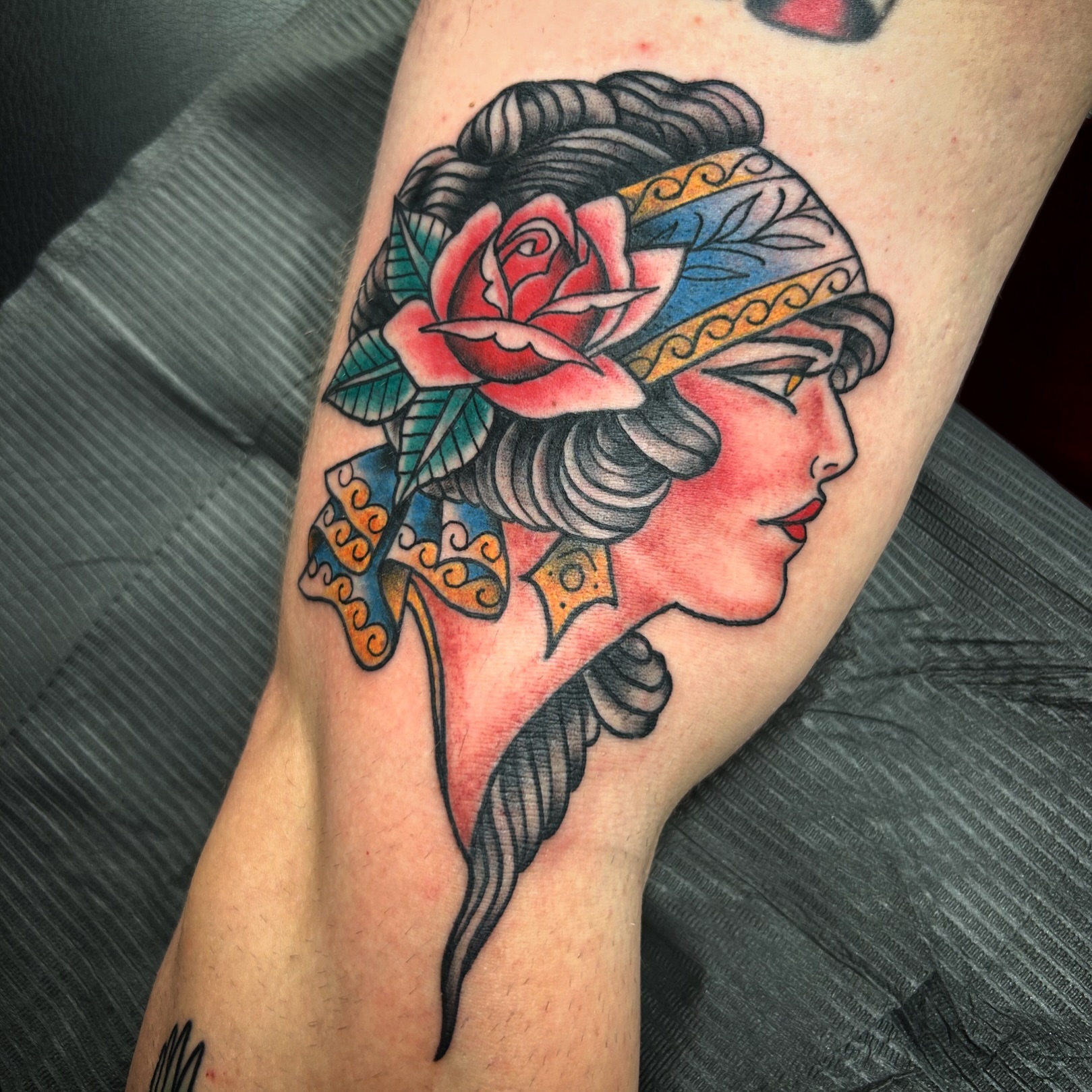 Woman with rose American traditional tattoo on the forearm by Patricia Cunningham