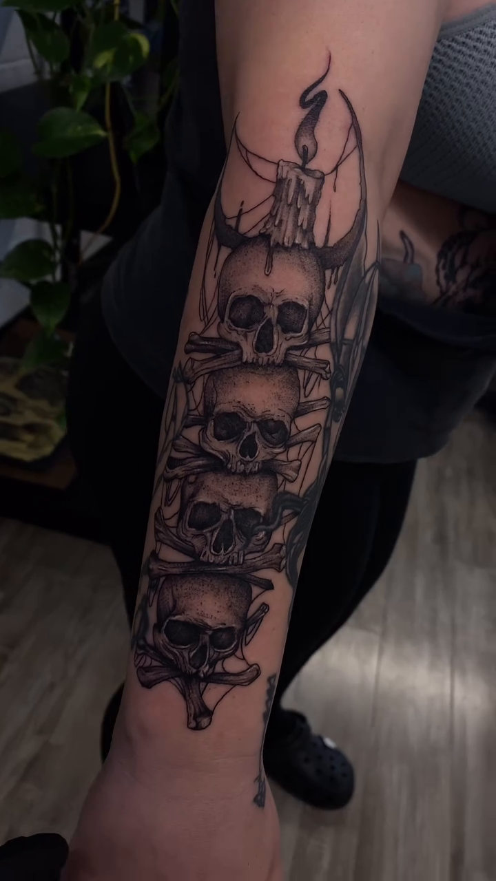 Stack of skulls and candle dark realism tattoo by Ryan Walker