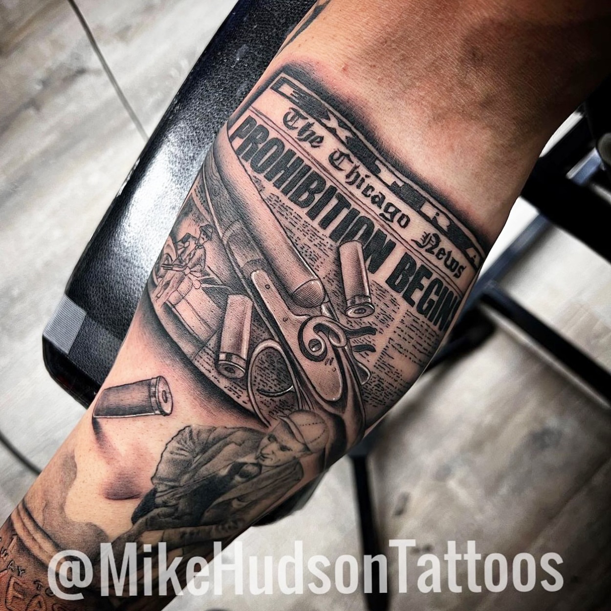 Prohibition newspaper black and grey tattoo on the forearm by Mike Hudson