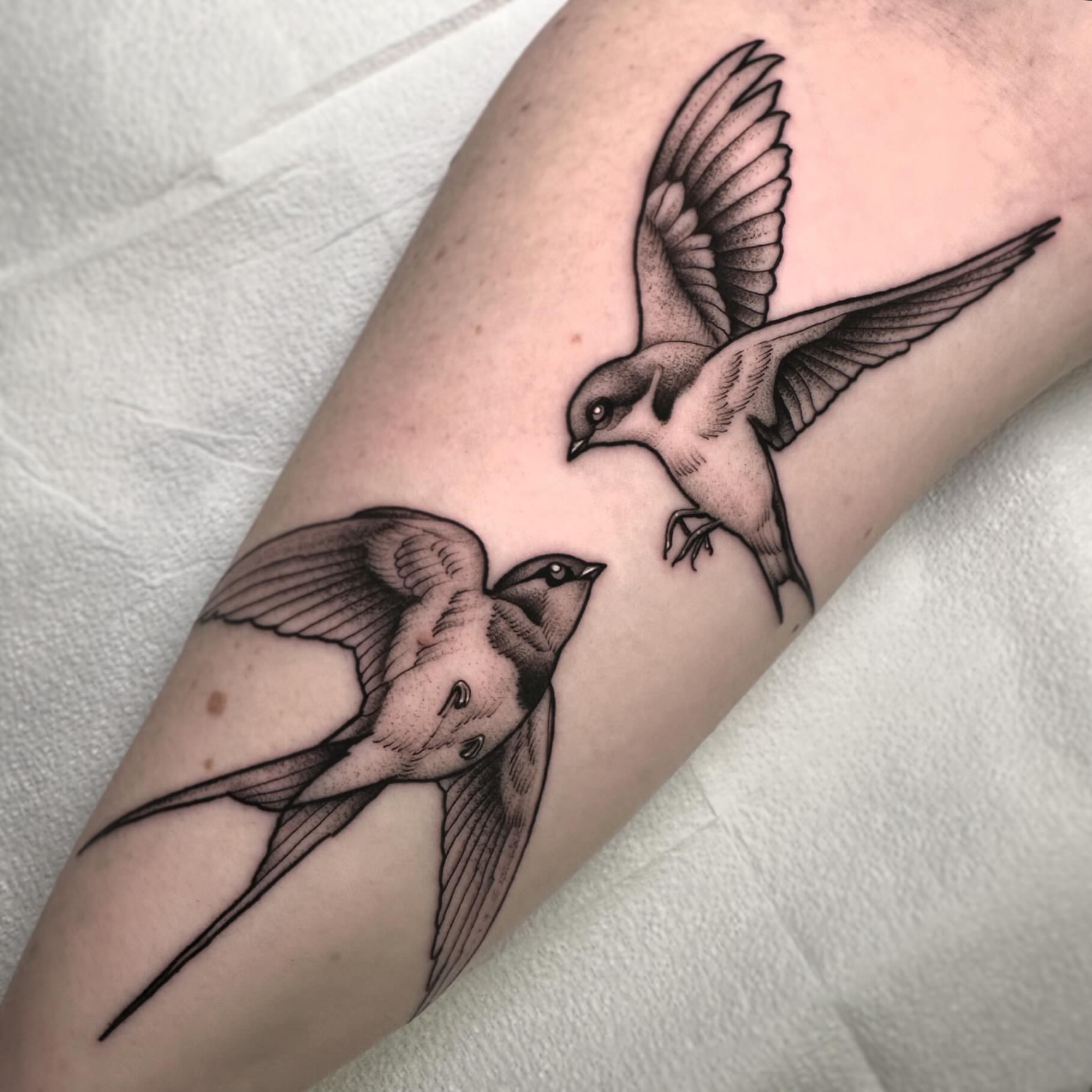 Swallows black and grey tattoo on the forearm by Patrick Whiting