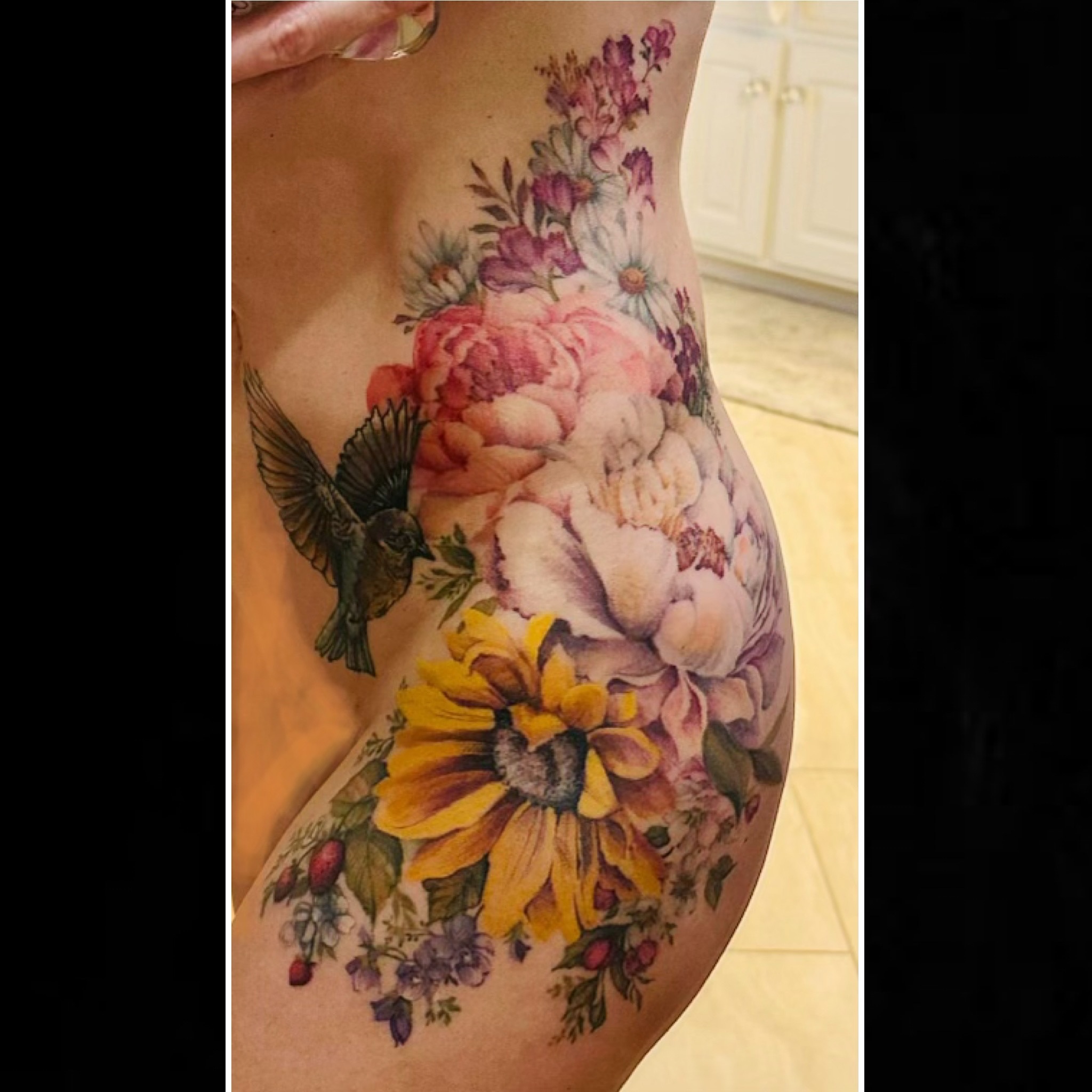 Floral bouquet with bird watercolor tattoo on the thigh by Sarah Spread