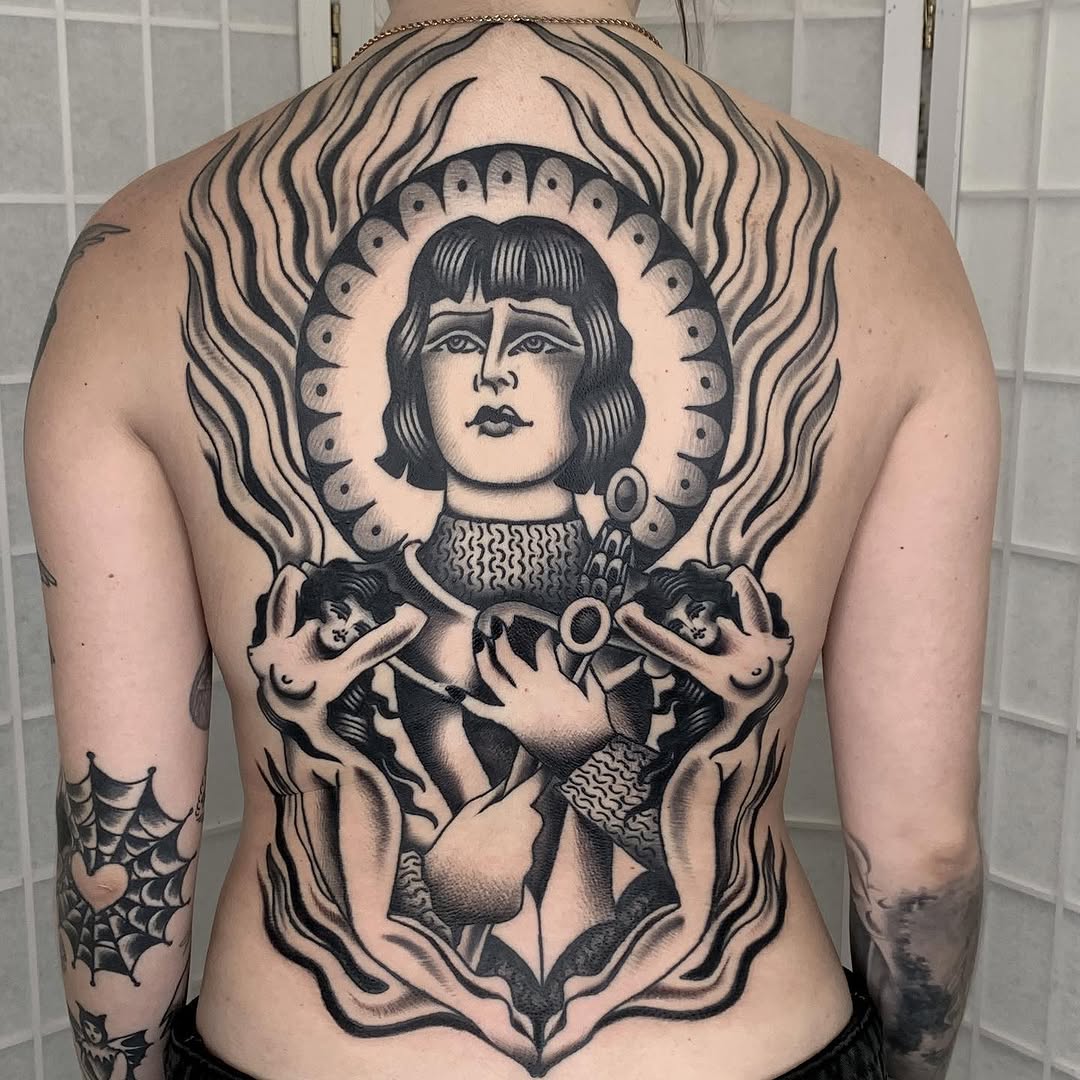 Figure with flames and cherubs realism tattoo on the back by Claire Anderson
