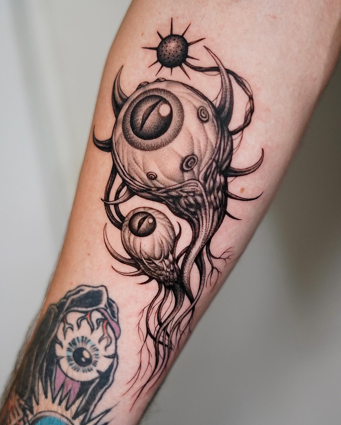 Eyes and tentacles surrealism tattoo on the forearm by Monkey Bob Tattoo