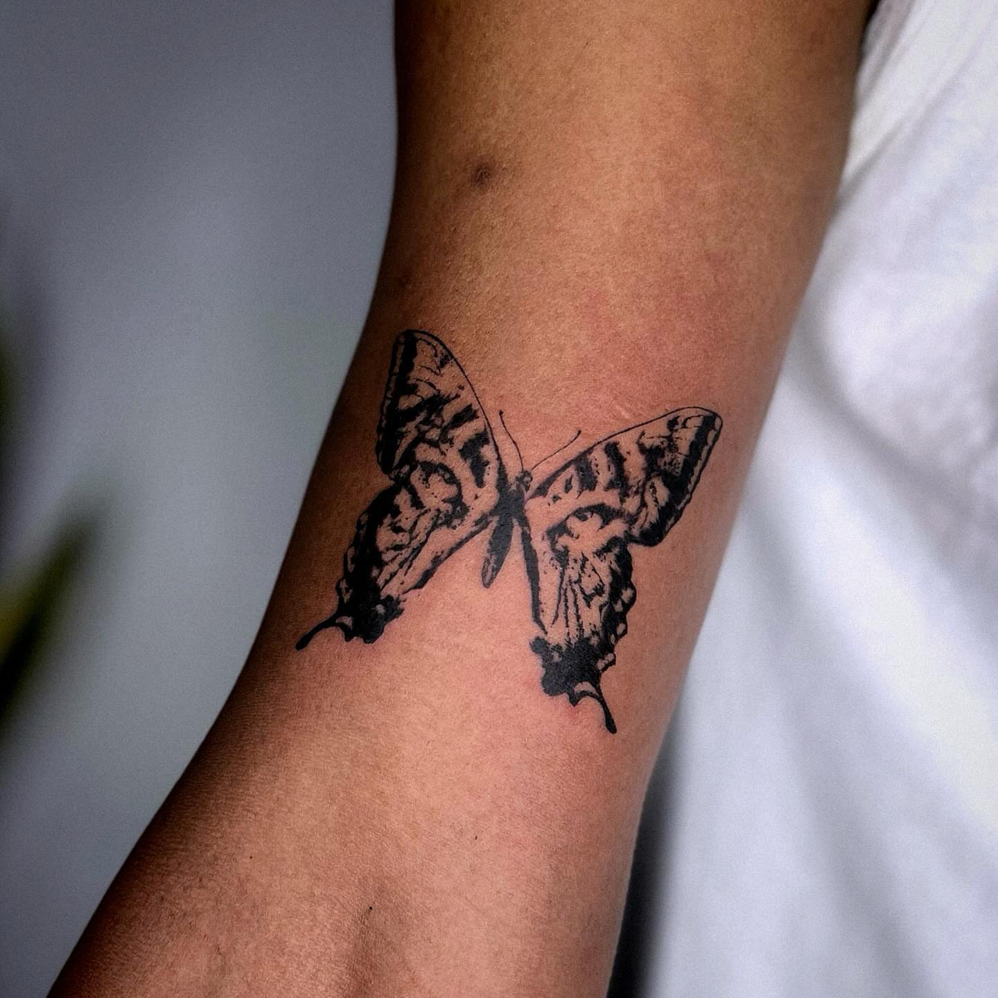 Butterfly black and grey tattoo on the forearm by Gabriel