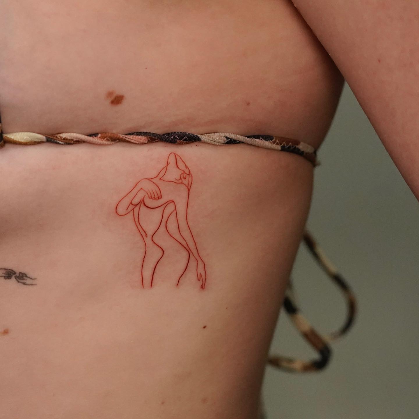 Abstract figure minimalist tattoo on the torso by eddie chavez