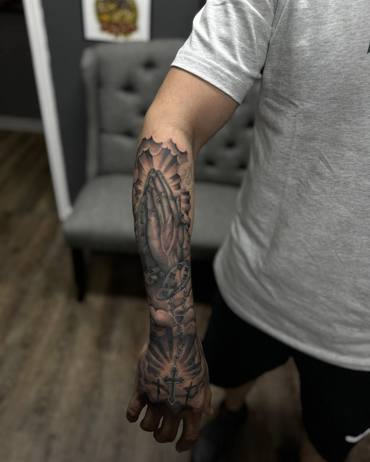 Praying hands with rosary black and grey tattoo on the forearm by Chris_Tatt2_D’Ascenzo