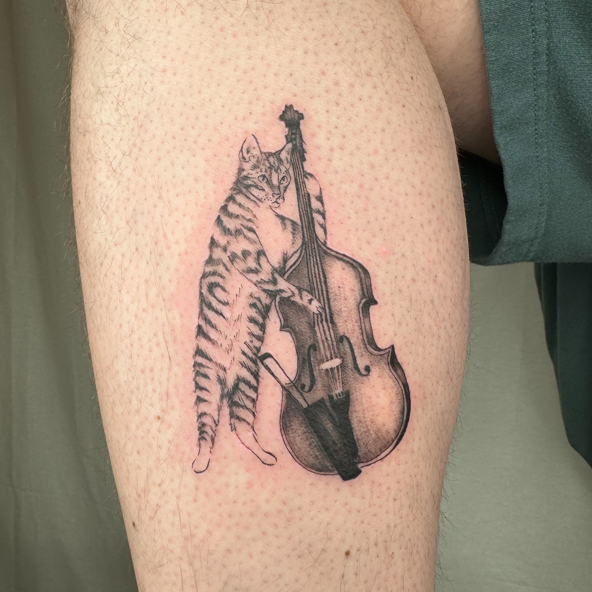 Cat playing cello realism tattoo on the thigh by RyAnn Lynn