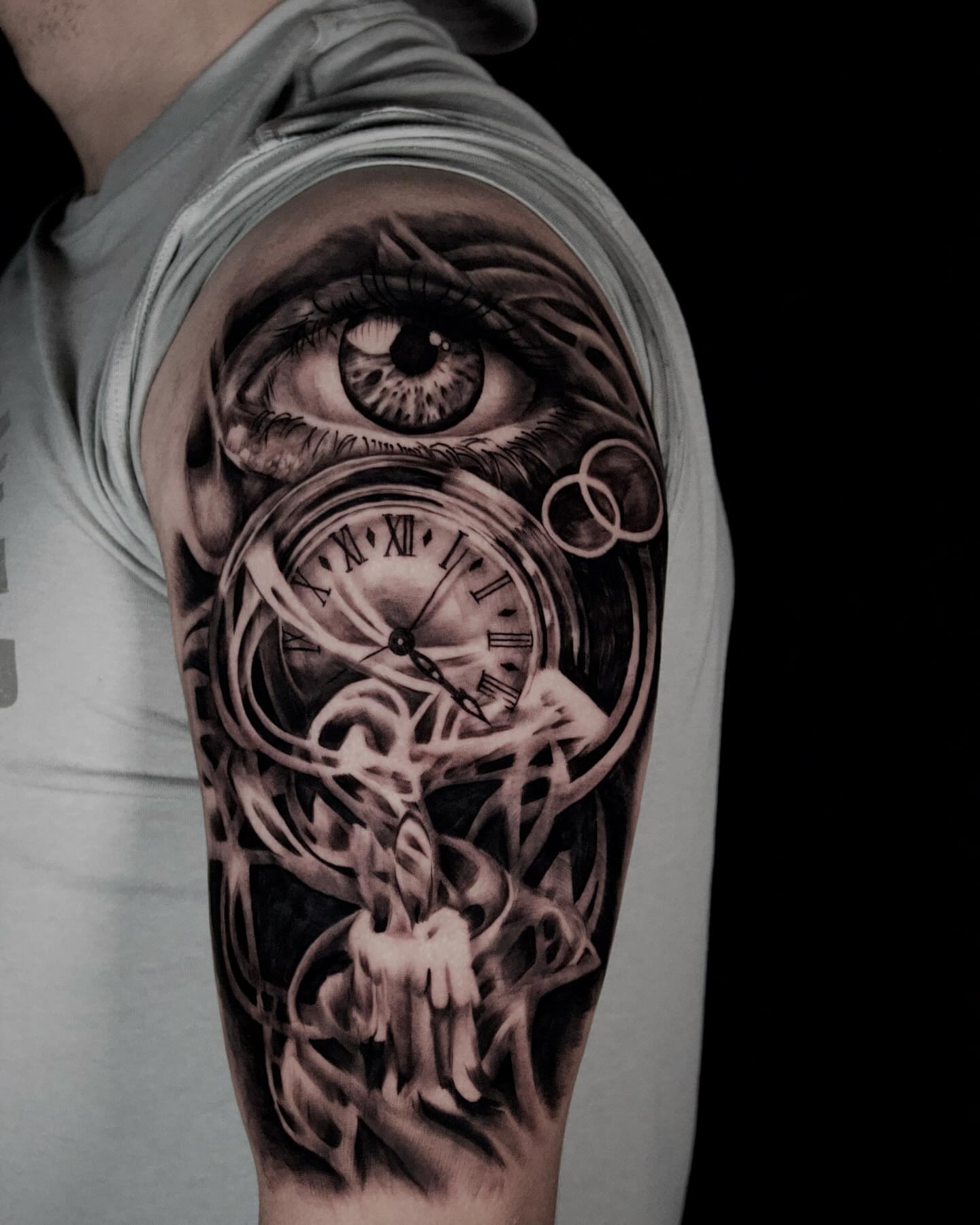 Eye and clock realism tattoo on the upper arm by Alex Suarez