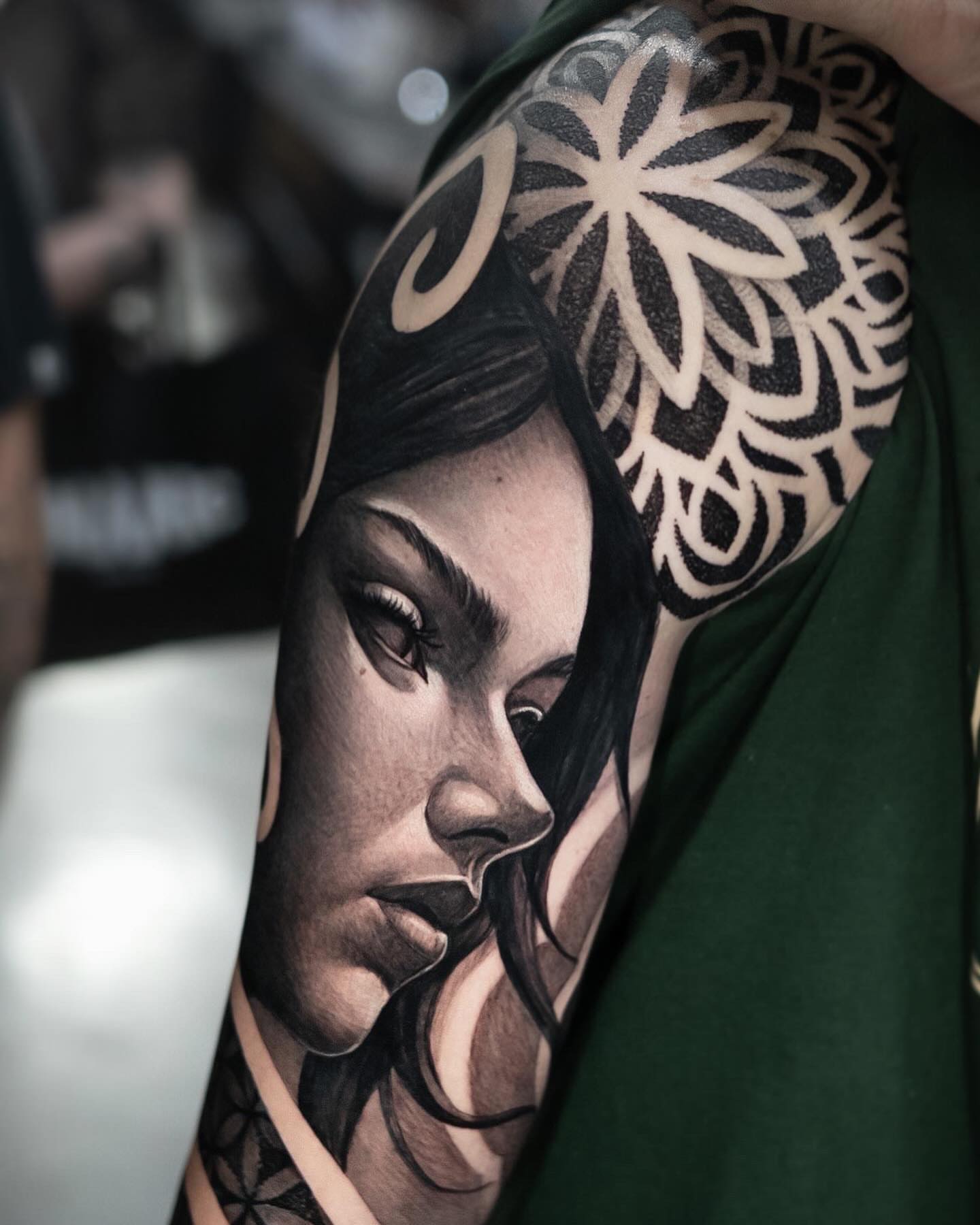 Woman's face realism tattoo on the upper arm by Luis Gil
