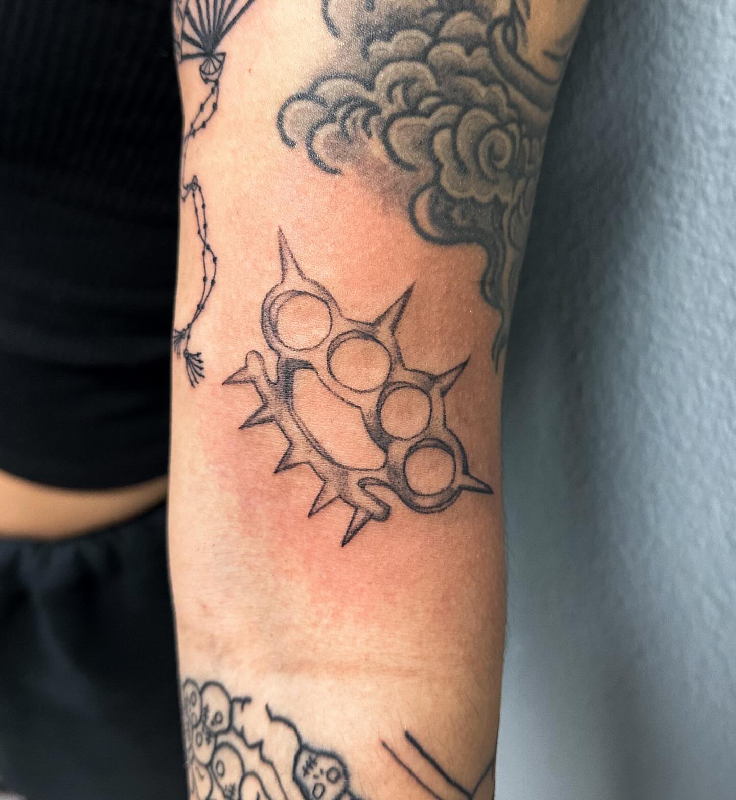 Knuckle dusters black and grey tattoo on the forearm by Portland Tattoo Artist
