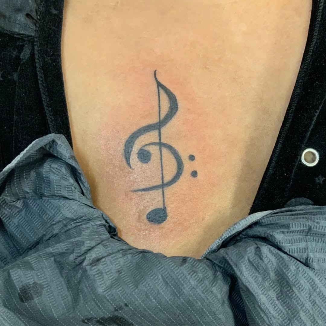 Treble clef and musical notes tribal tattoo on the ribs by Lopez Dautruche