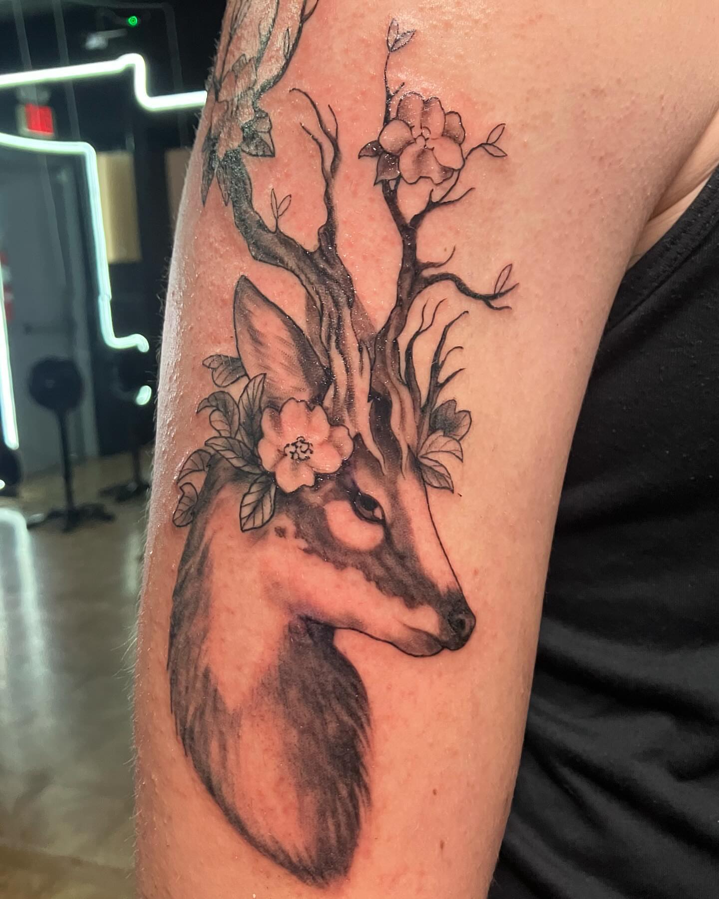 Deer with floral crown realism tattoo on the forearm by Hunter McGinnis