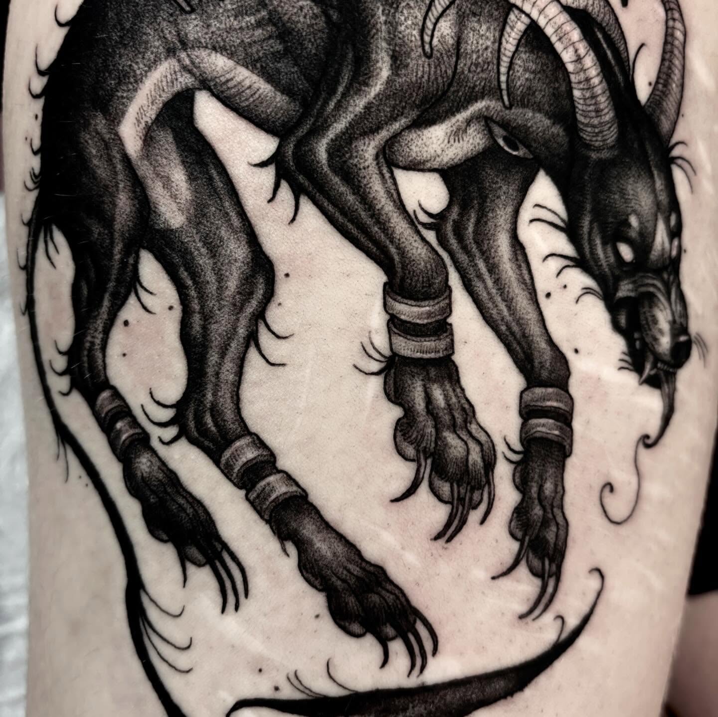 Goat-like creature black and grey tattoo on the forearm by Jens