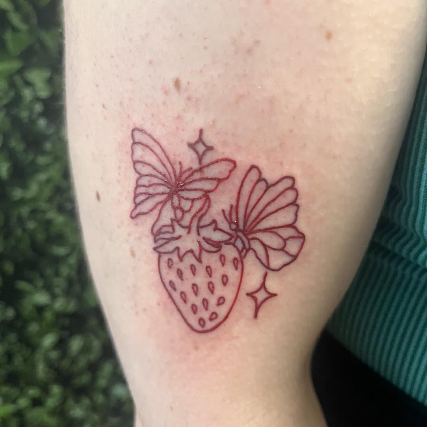 Strawberry and butterflies fine line tattoo on the forearm by Michelle