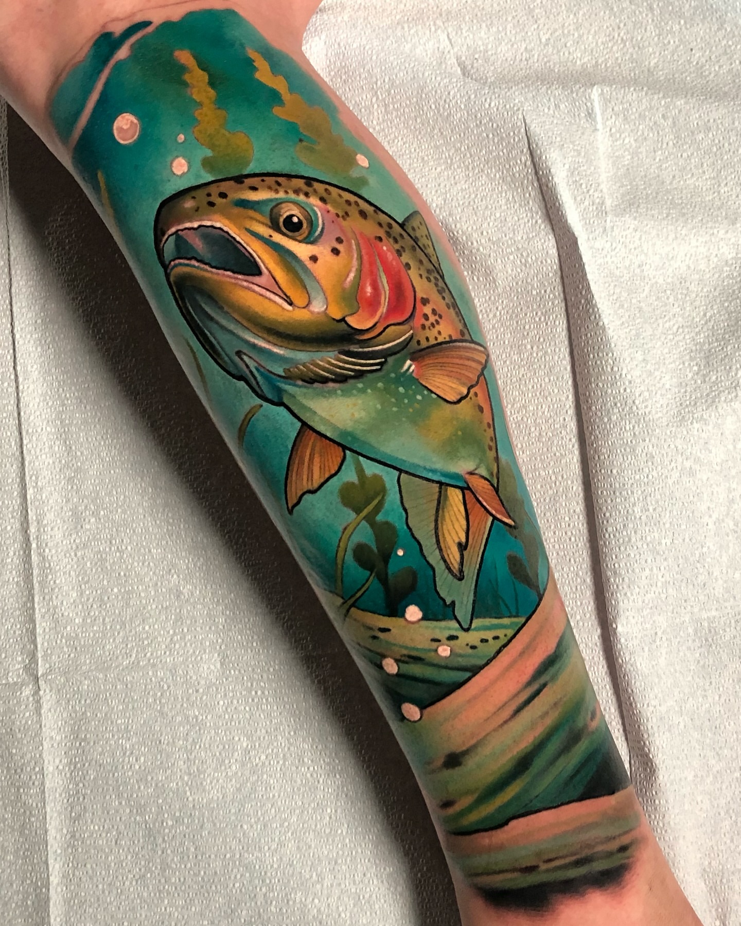 Rainbow trout realism tattoo on the forearm by Milo Alfring Tattoo